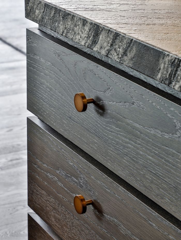 Textural stone benchtops complement the dark timber cabinetry.