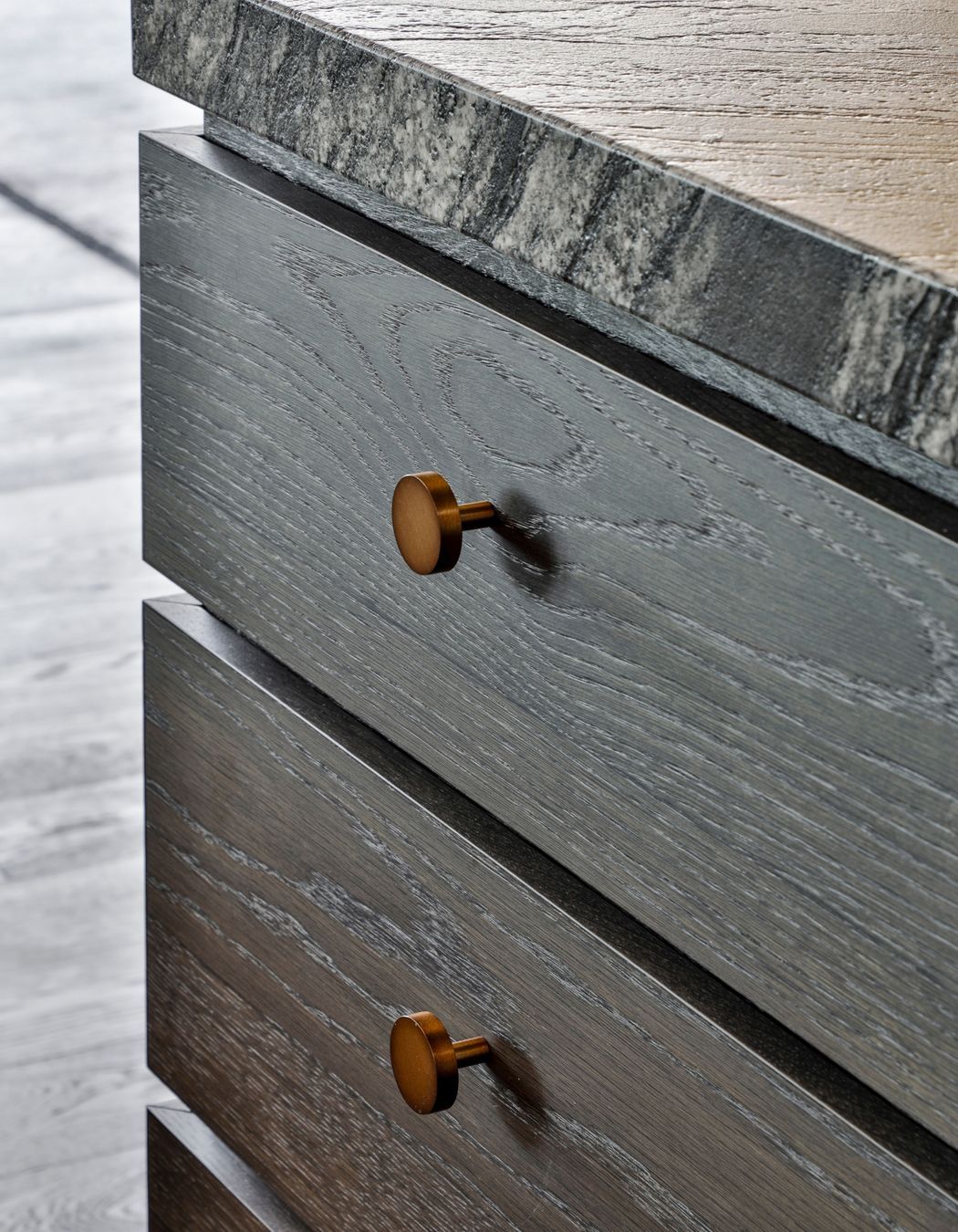 Textural stone benchtops complement the dark timber cabinetry.