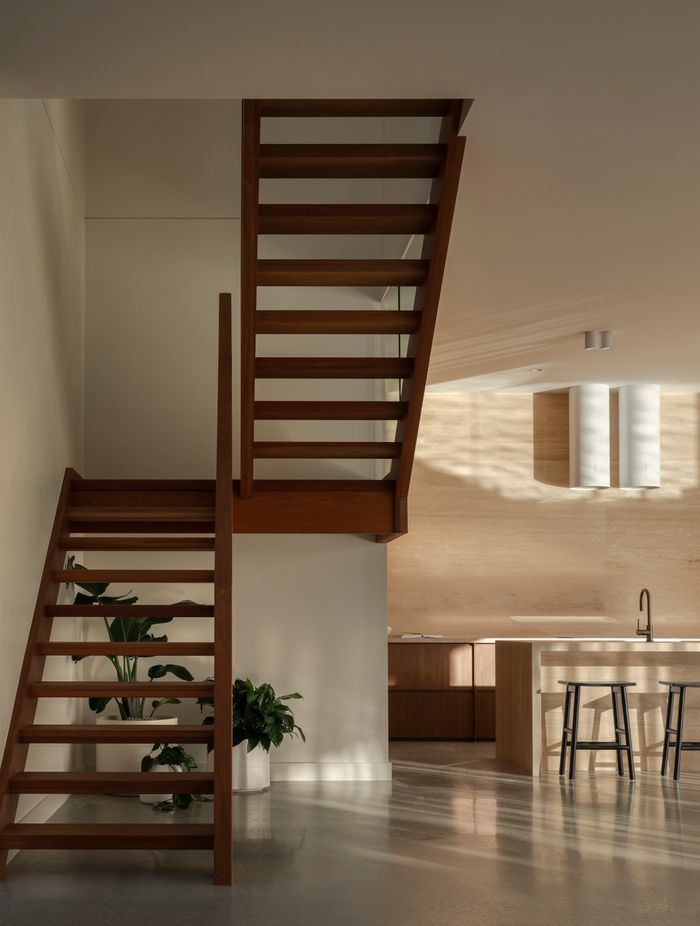 The entry opens to a double void, with the open-plan kitchen, living and dining beyond.