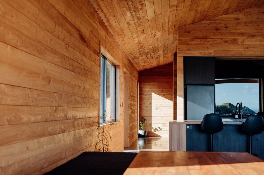The interior macrocarpa brings a warmth to the living areas, and the island bench waterfall ends use recycled Totara from the farm woolshed.