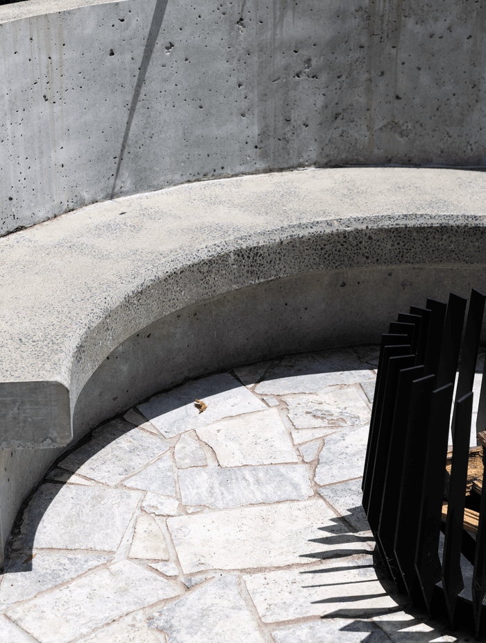 Curves, concrete and stone continue to the backyard where the family can gather around the fire pit.