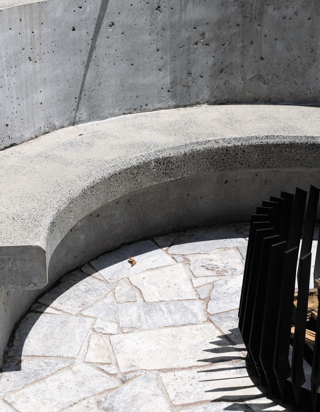 Curves, concrete and stone continue to the backyard where the family can gather around the fire pit.
