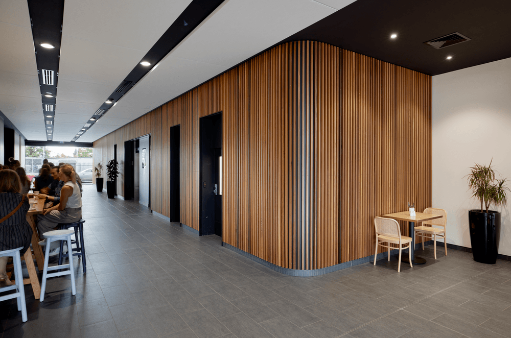 The foyer features a timber slatted wall that wraps right from outside to the lifts.