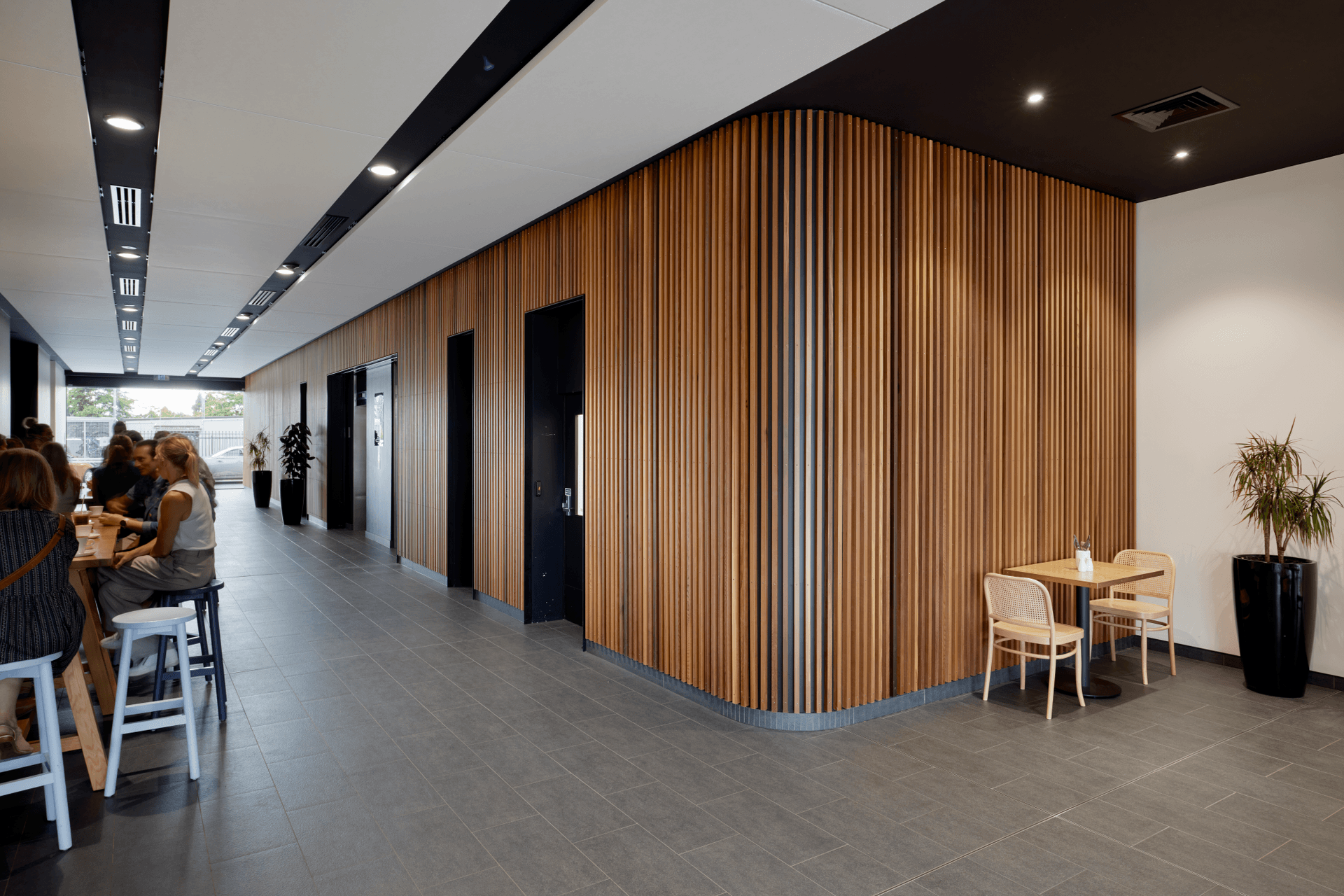 The foyer features a timber slatted wall that wraps right from outside to the lifts.
