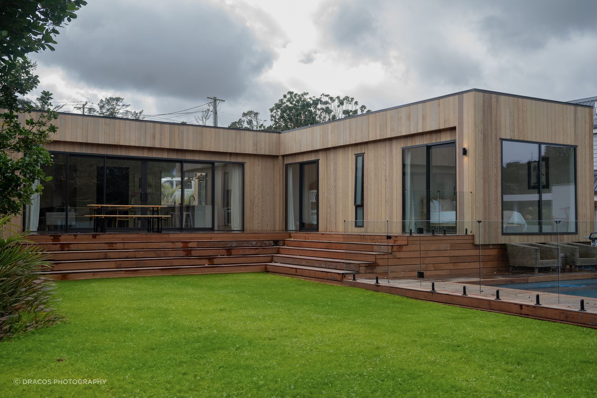 Vertical cedar cladding wraps the entire home, complimented by the rich kwila decking.