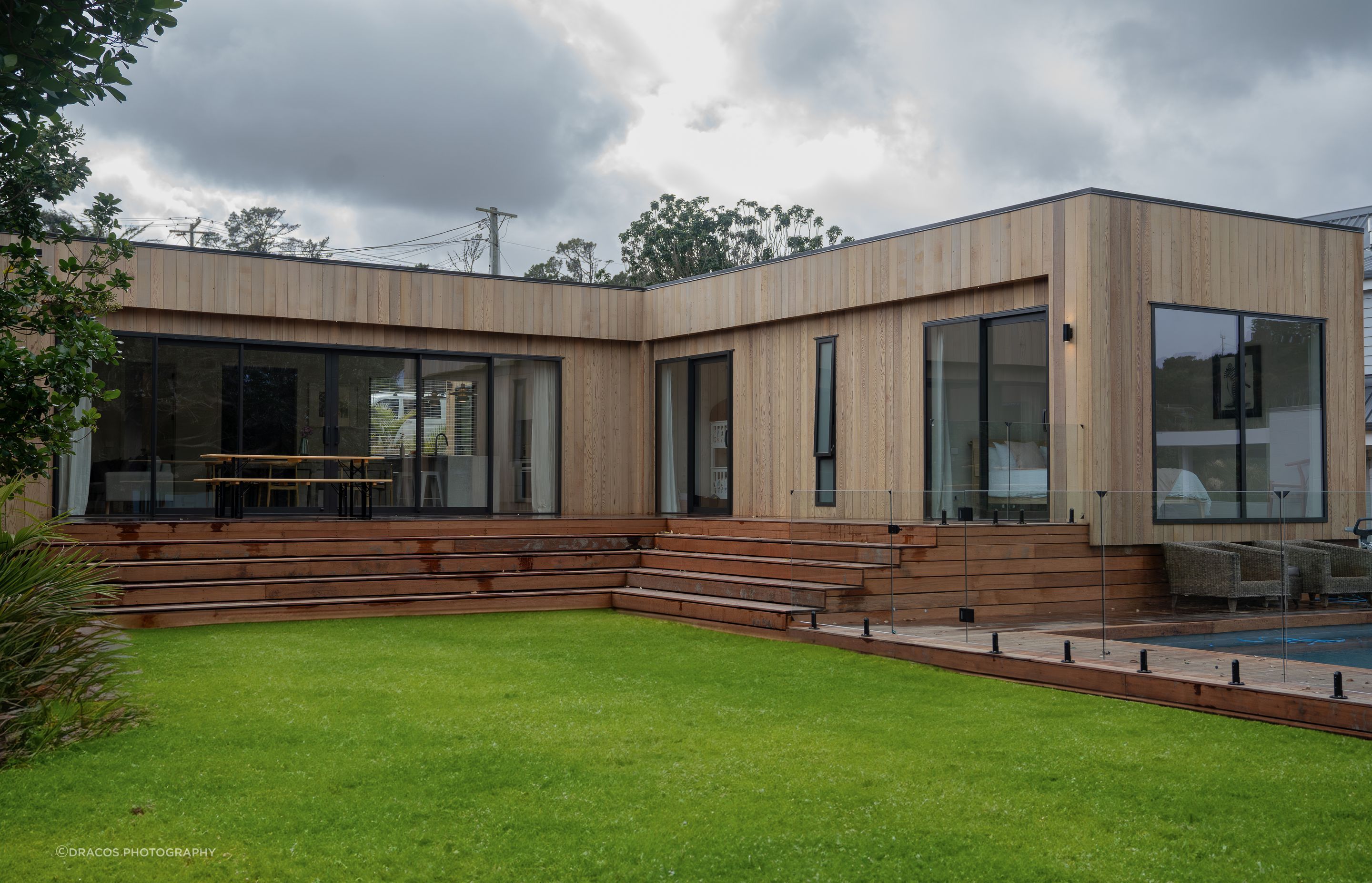 Vertical cedar cladding wraps the entire home, complimented by the rich kwila decking.