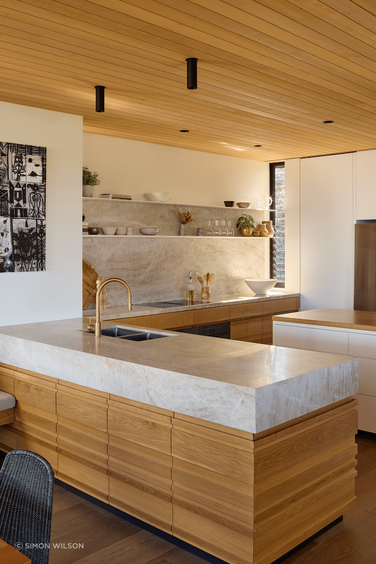 Natural stone complements the timber in the kitchen, which overlooks the dining and lounge areas.