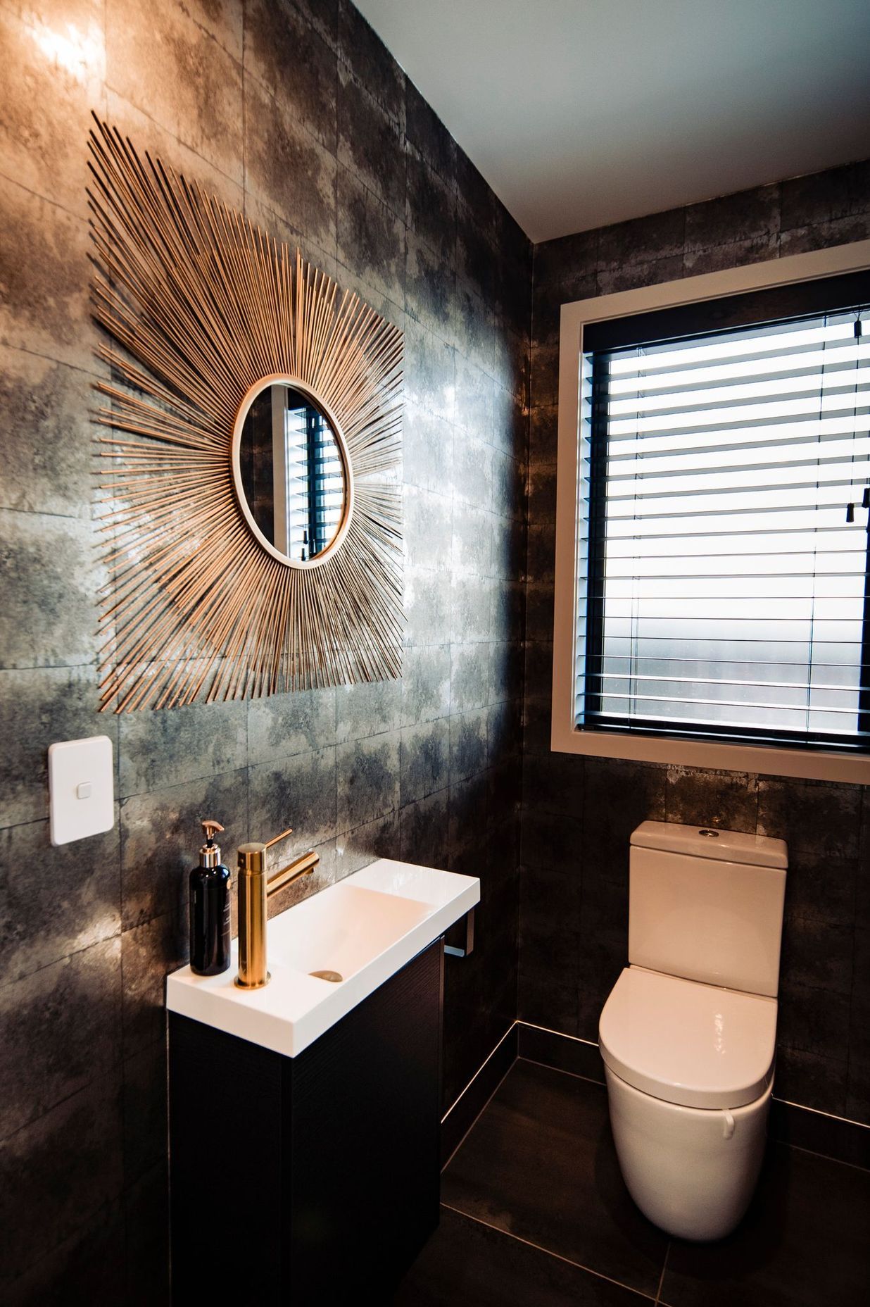 The powder room makes a statement with wallpaper and brass accents.