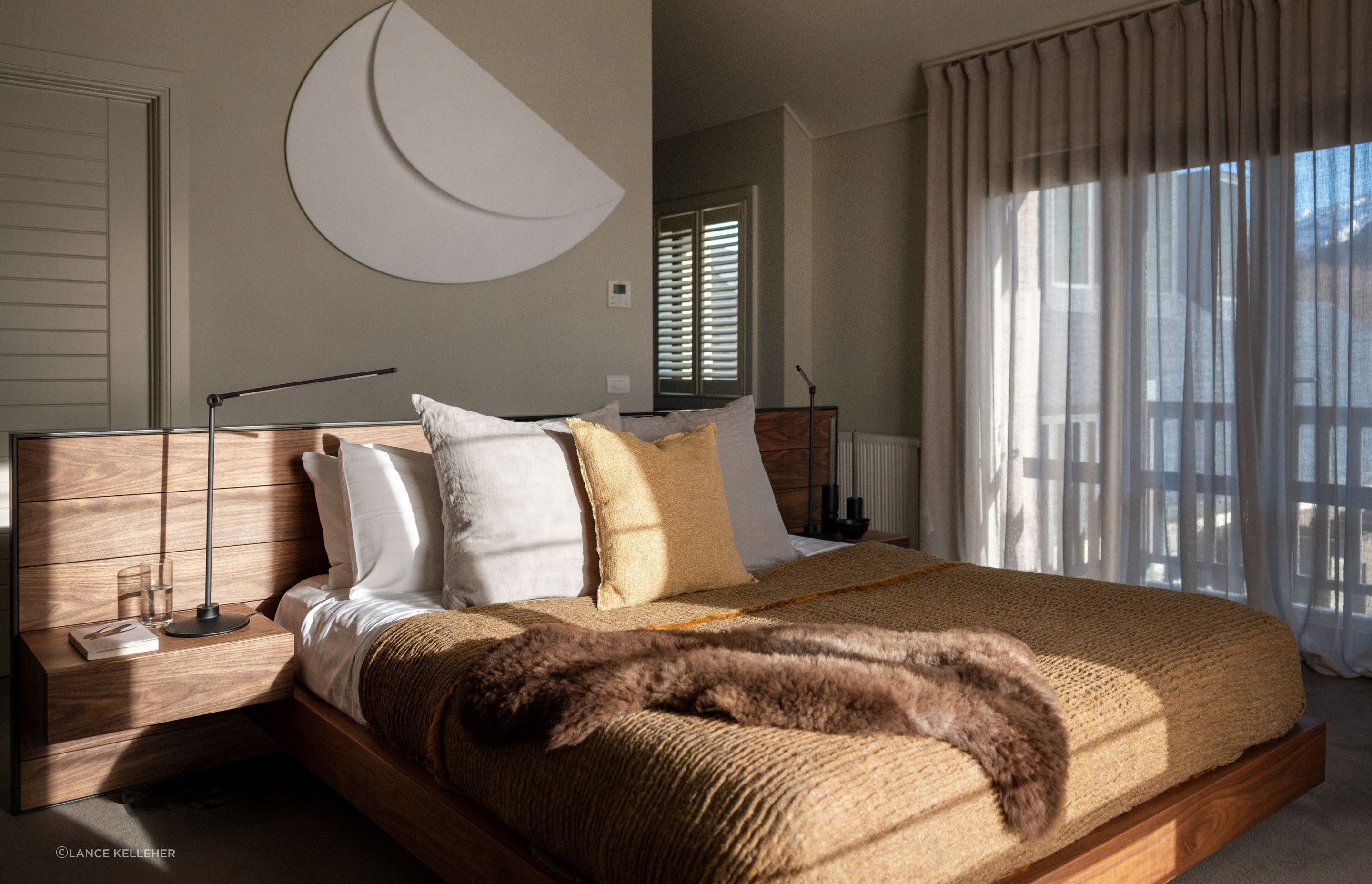 The client's sculptural artwork fits in perfectly in the serene master bedroom on the wall behind the bed; the headboard was moved perpendicular in the final layout, so that the bed faces directly out to the mountain view.