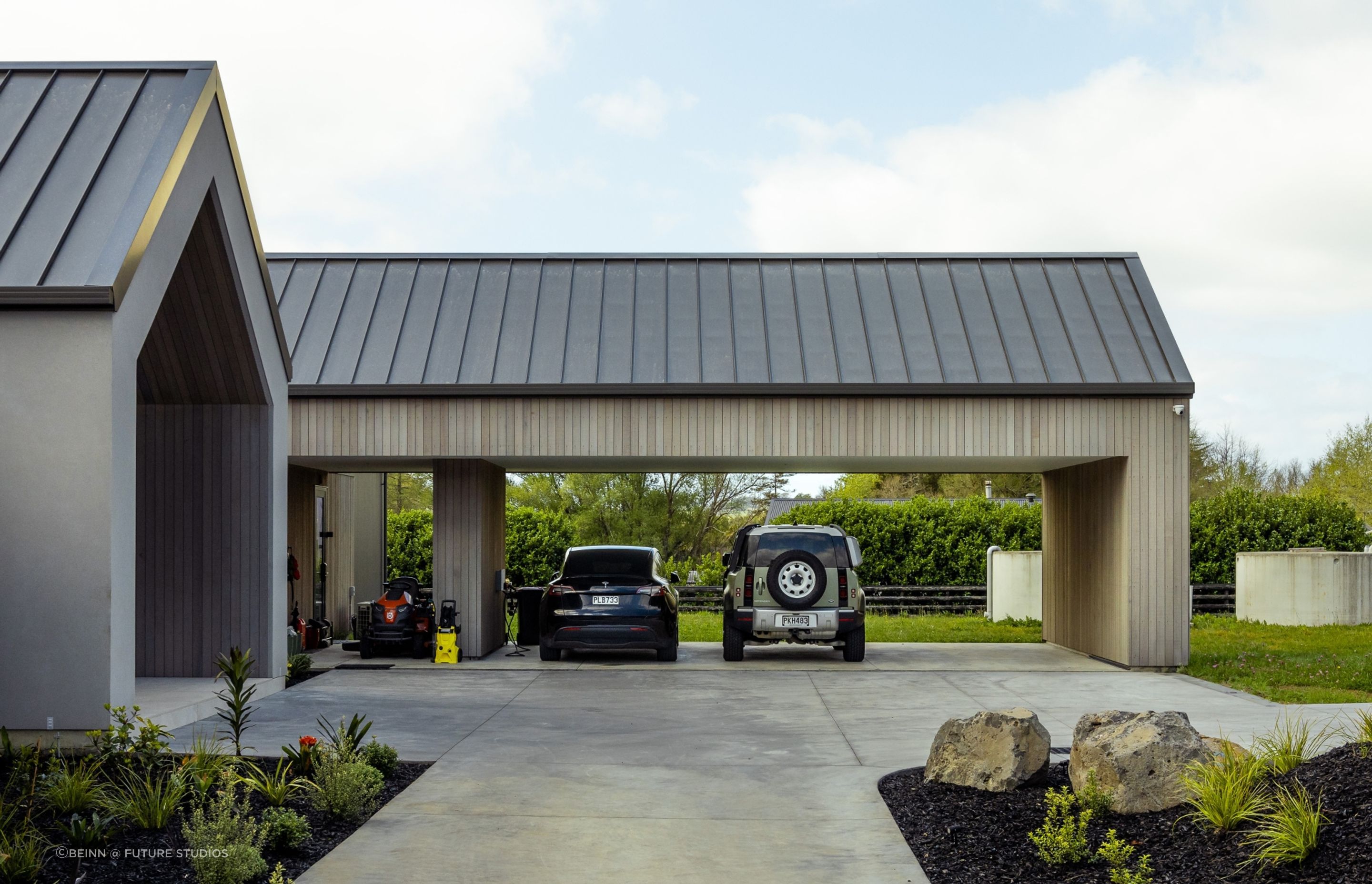 A cedar-clad carport is neatly contained in a gable form.