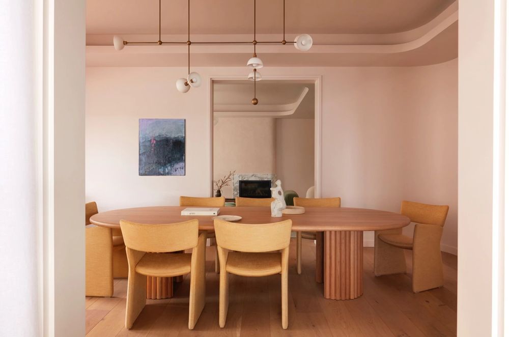 The pastel pink wraps around the curved walls of the formal dining room.