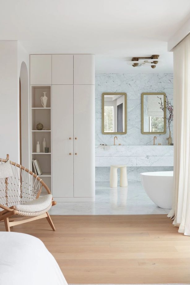 More restrained in colour palette, the bedroom flows into the ensuite.