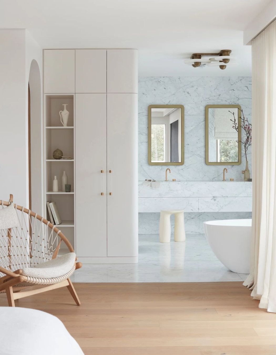 More restrained in colour palette, the bedroom flows into the ensuite.