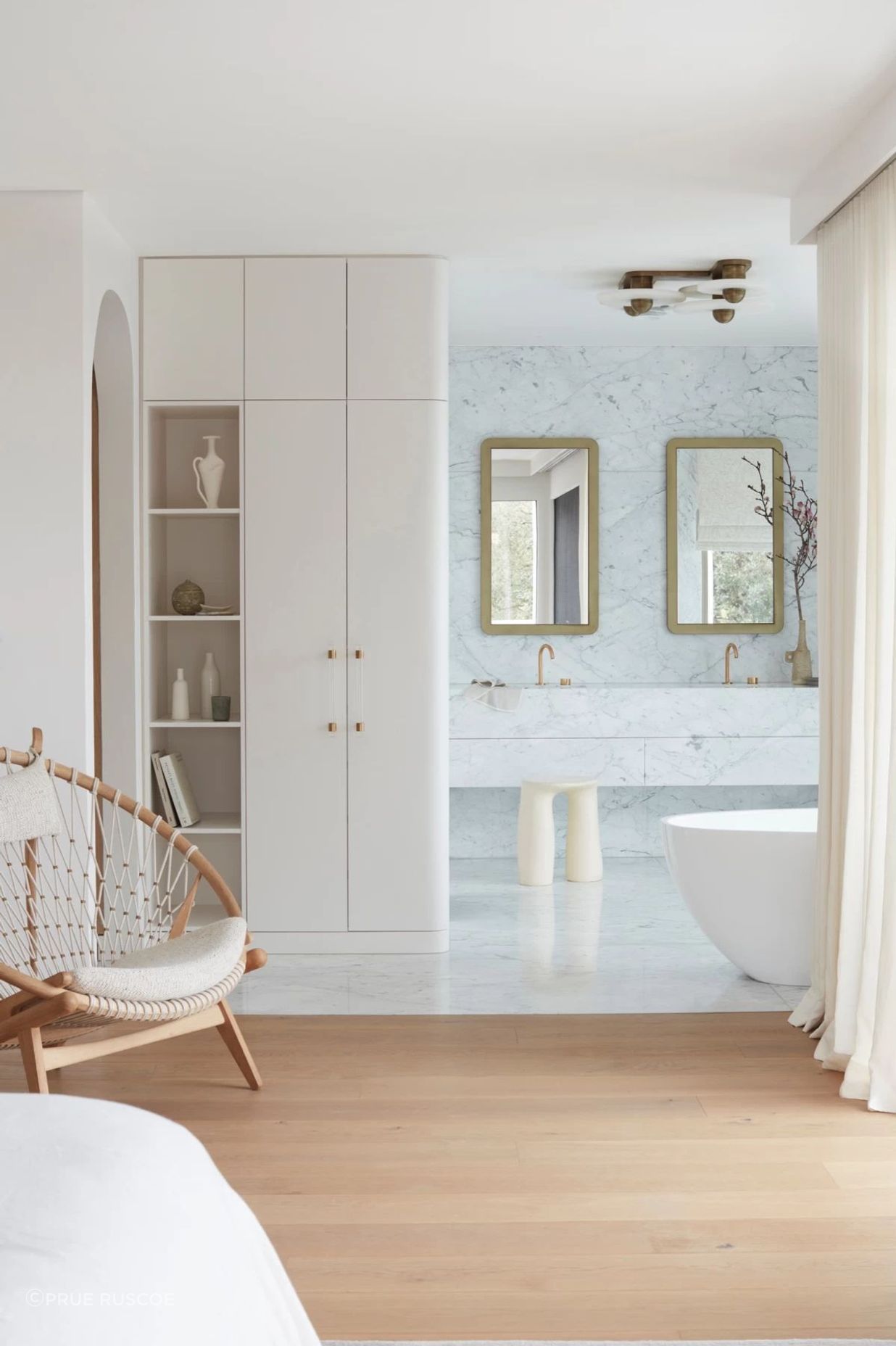 More restrained in colour palette, the bedroom flows into the ensuite.