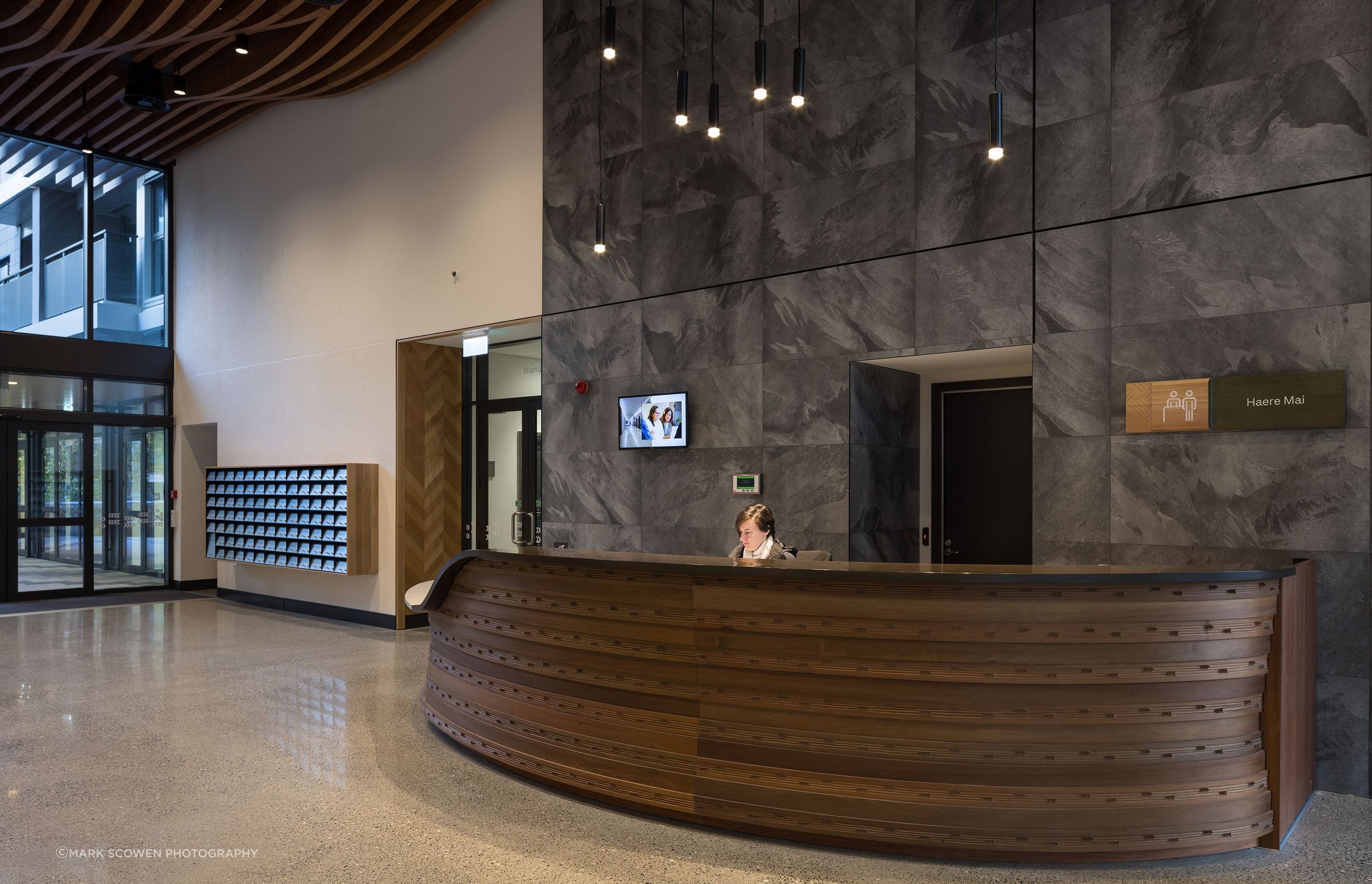 The beautifully carved concierge desk welcomes residents to Te Mātāwai.