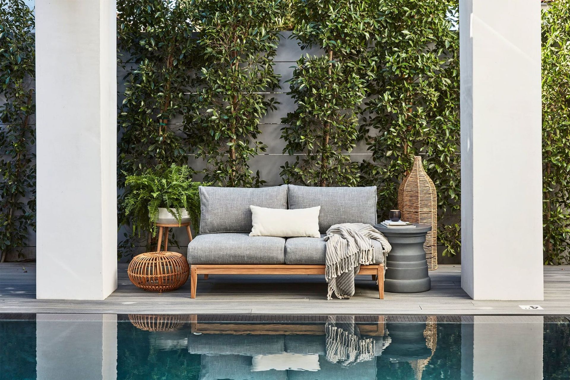 The plush Teak Outdoor Loveseat takes centre stage in a scene that completely embodies comfort
