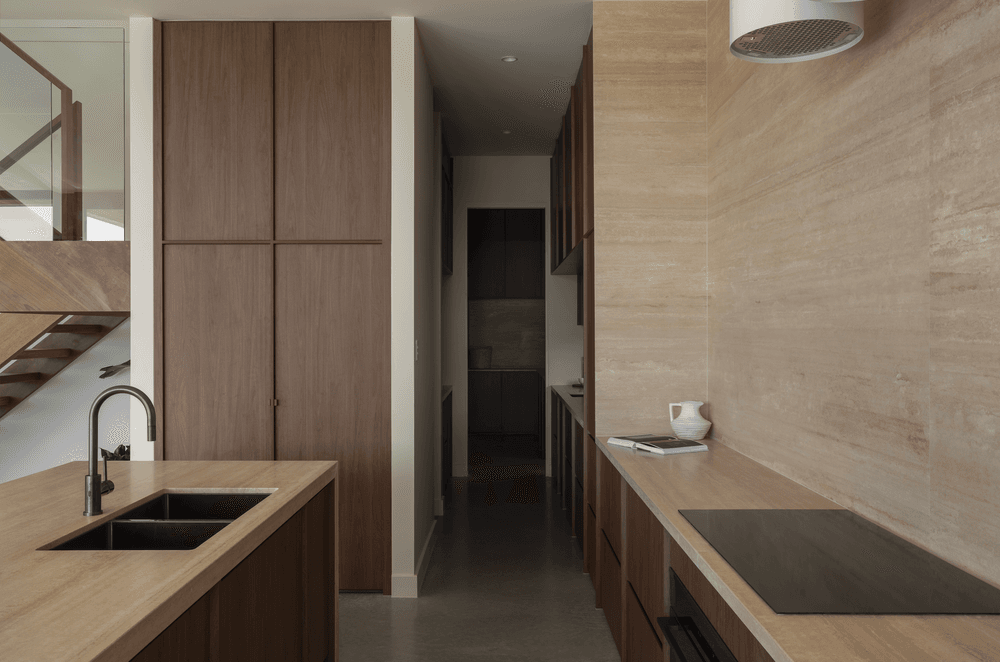 Chocolate-coloured timber cabinetry brings warmth to the kitchen, complete with a butler's pantry.