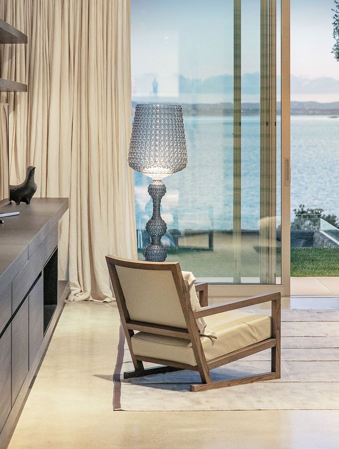 Sit in this elegant and comfortable armchair to enjoy a view of Waitemata Harbour and the terraced poolside area of Sea Wall House.