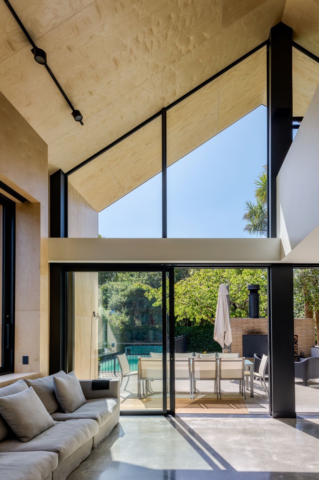 The double-height living area looking north towards the outdoor room and pool.