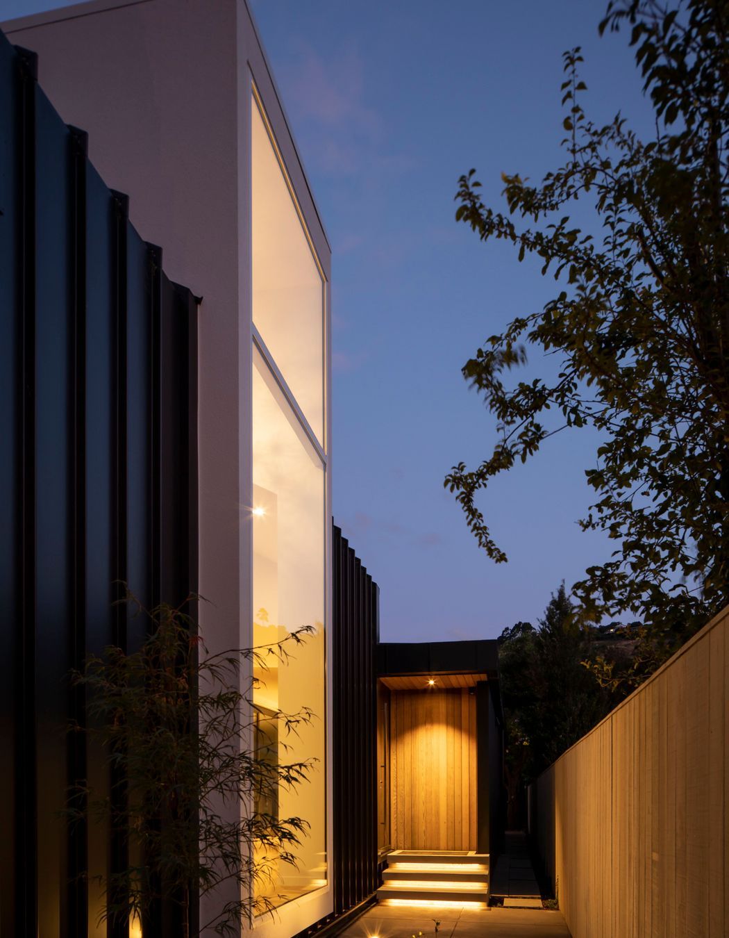 Located halfway down the building, the entrance draws visitors past a floor-to-ceiling window that looks into a double-height foyer-style entry. 