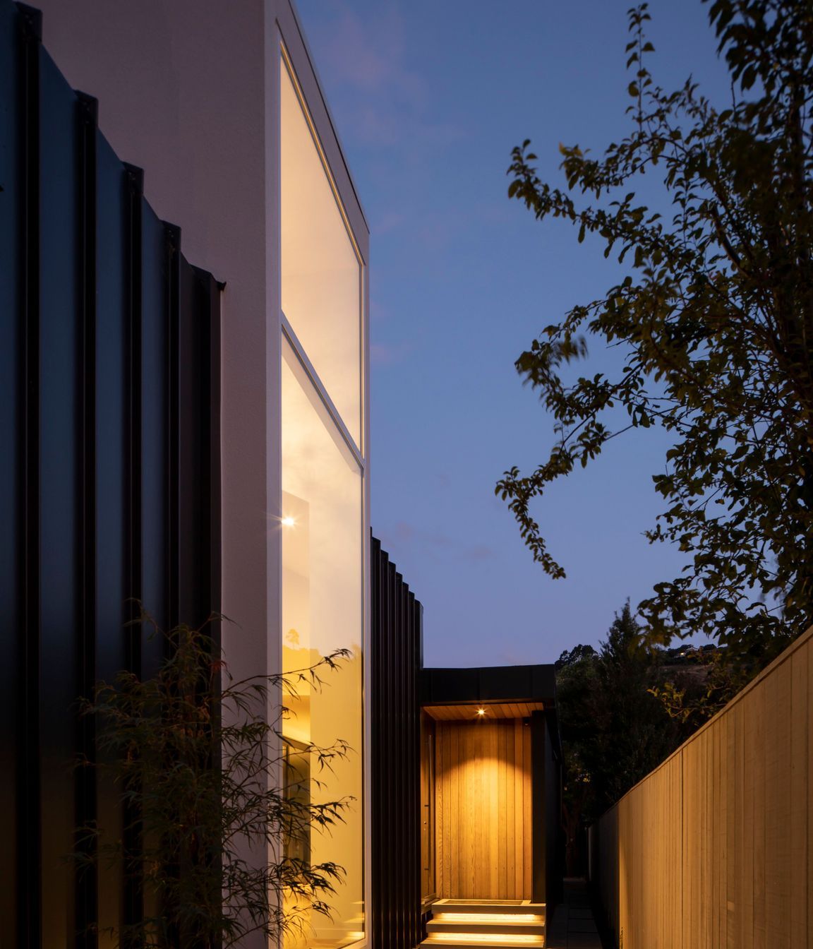 Located halfway down the building, the entrance draws visitors past a floor-to-ceiling window that looks into a double-height foyer-style entry. 