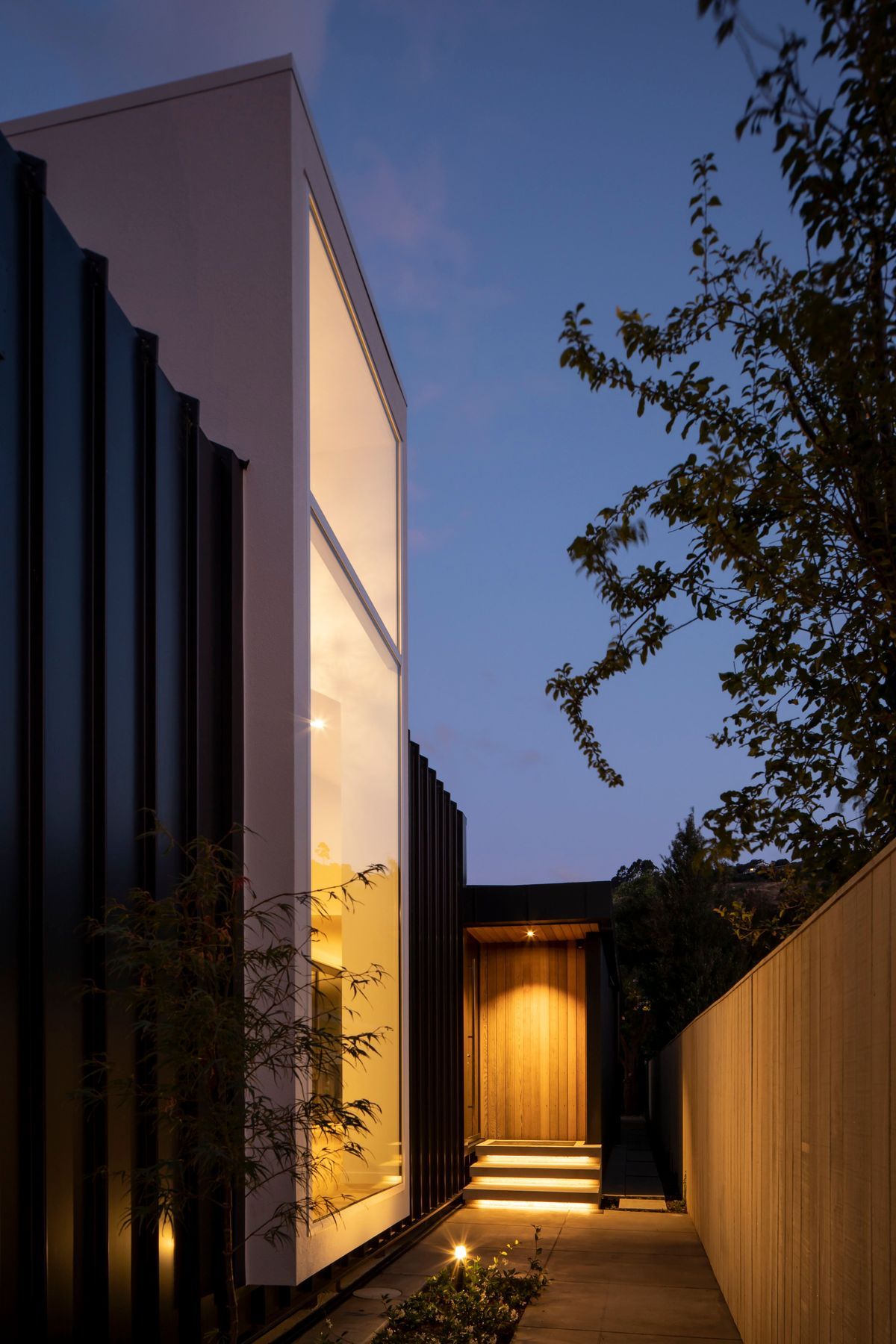 Located halfway down the building, the entrance draws visitors past a floor-to-ceiling window that looks into a double-height foyer-style entry. 