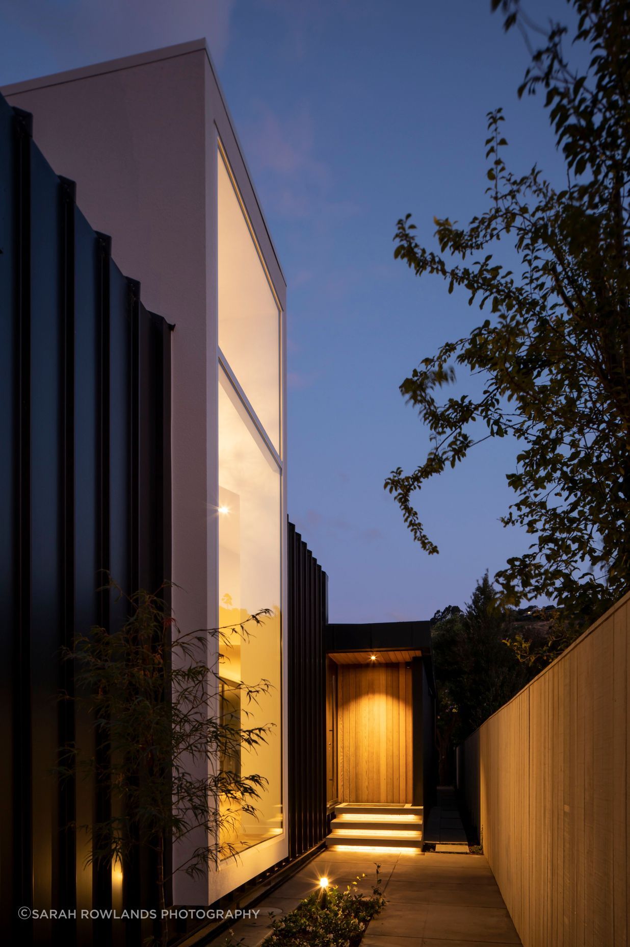 Located halfway down the building, the entrance draws visitors past a floor-to-ceiling window that looks into a double-height foyer-style entry.