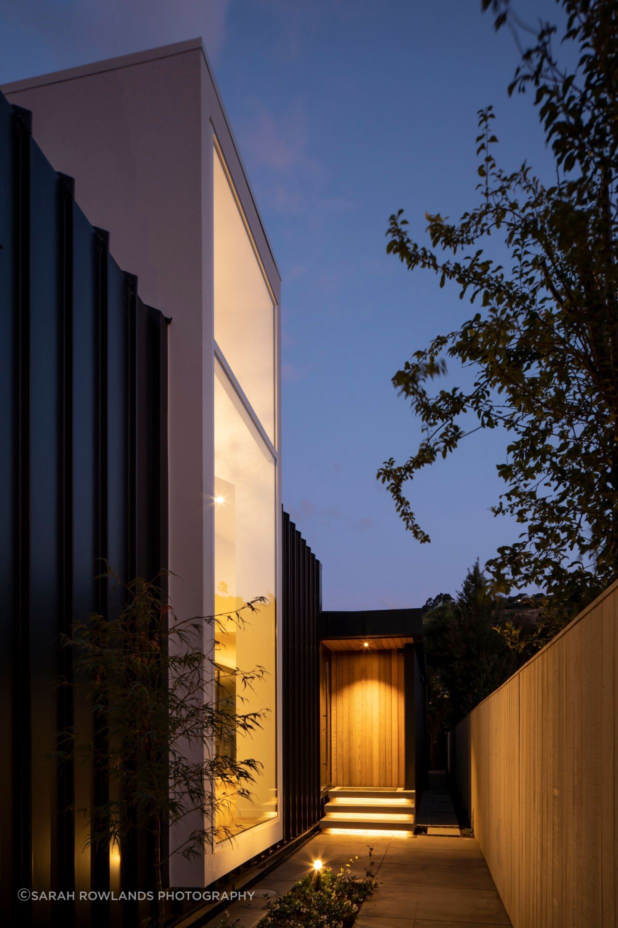 Located halfway down the building, the entrance draws visitors past a floor-to-ceiling window that looks into a double-height foyer-style entry. 