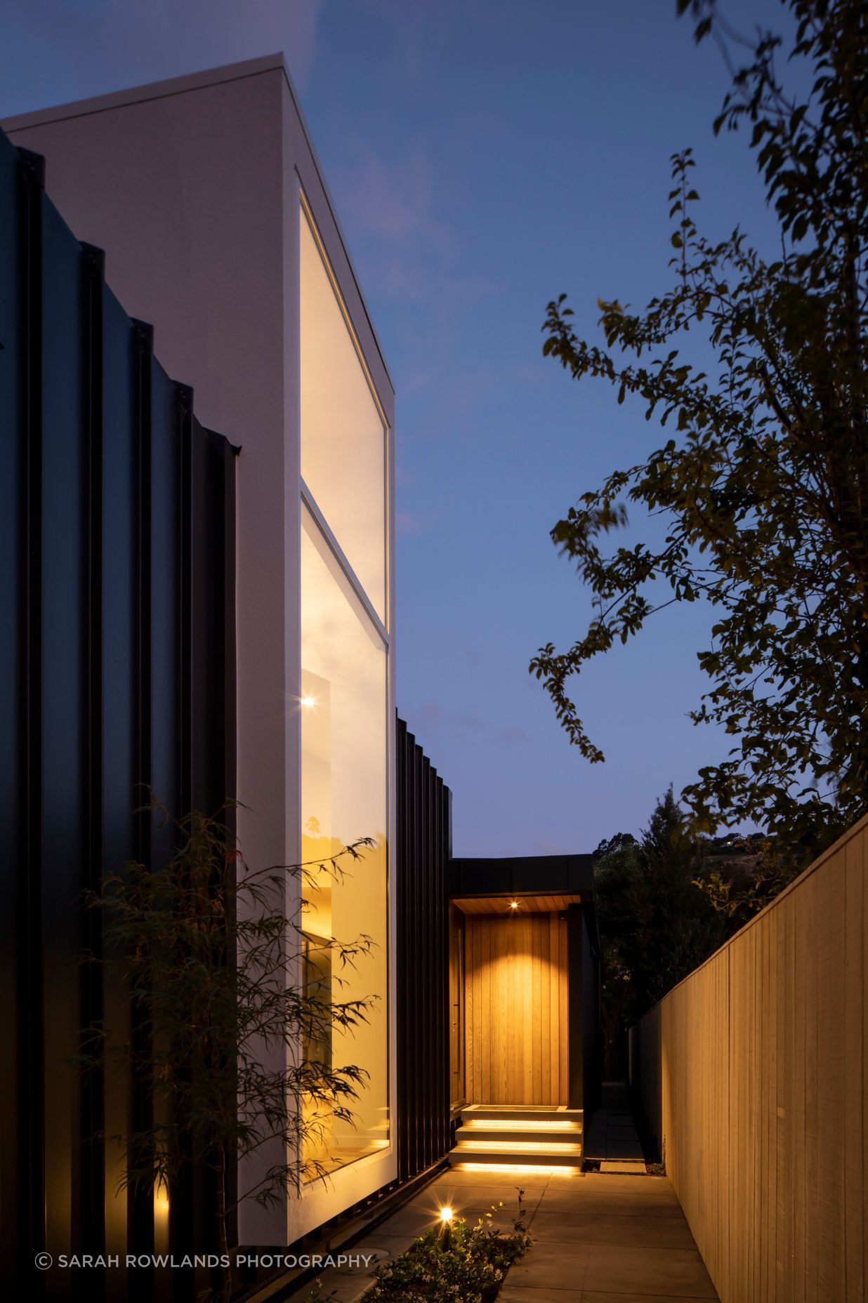 Located halfway down the building, the entrance draws visitors past a floor-to-ceiling window that looks into a double-height foyer-style entry.