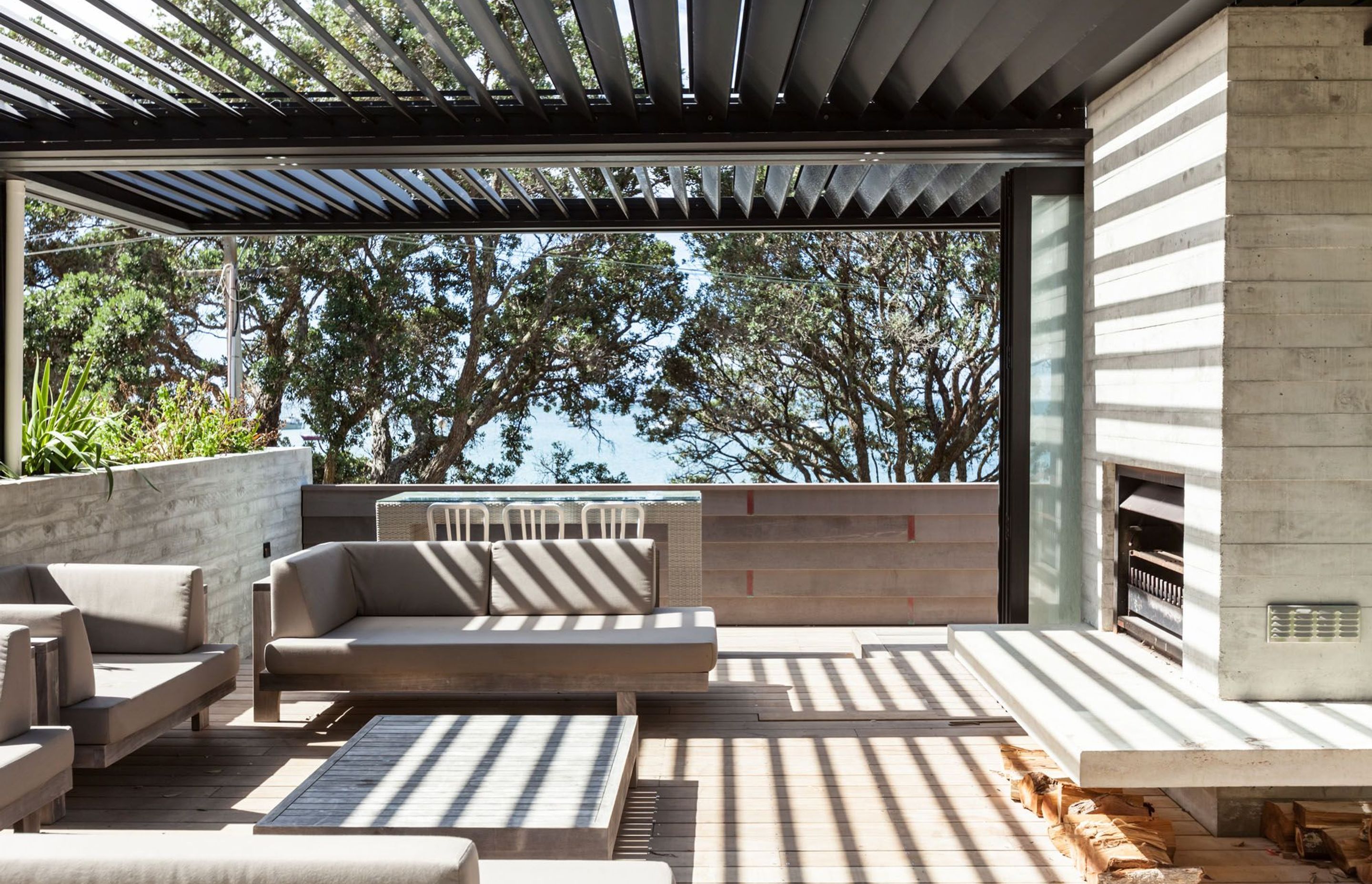 This stunning outdoor room in a Waiheke home features the motorised Locarno louvre roof system.