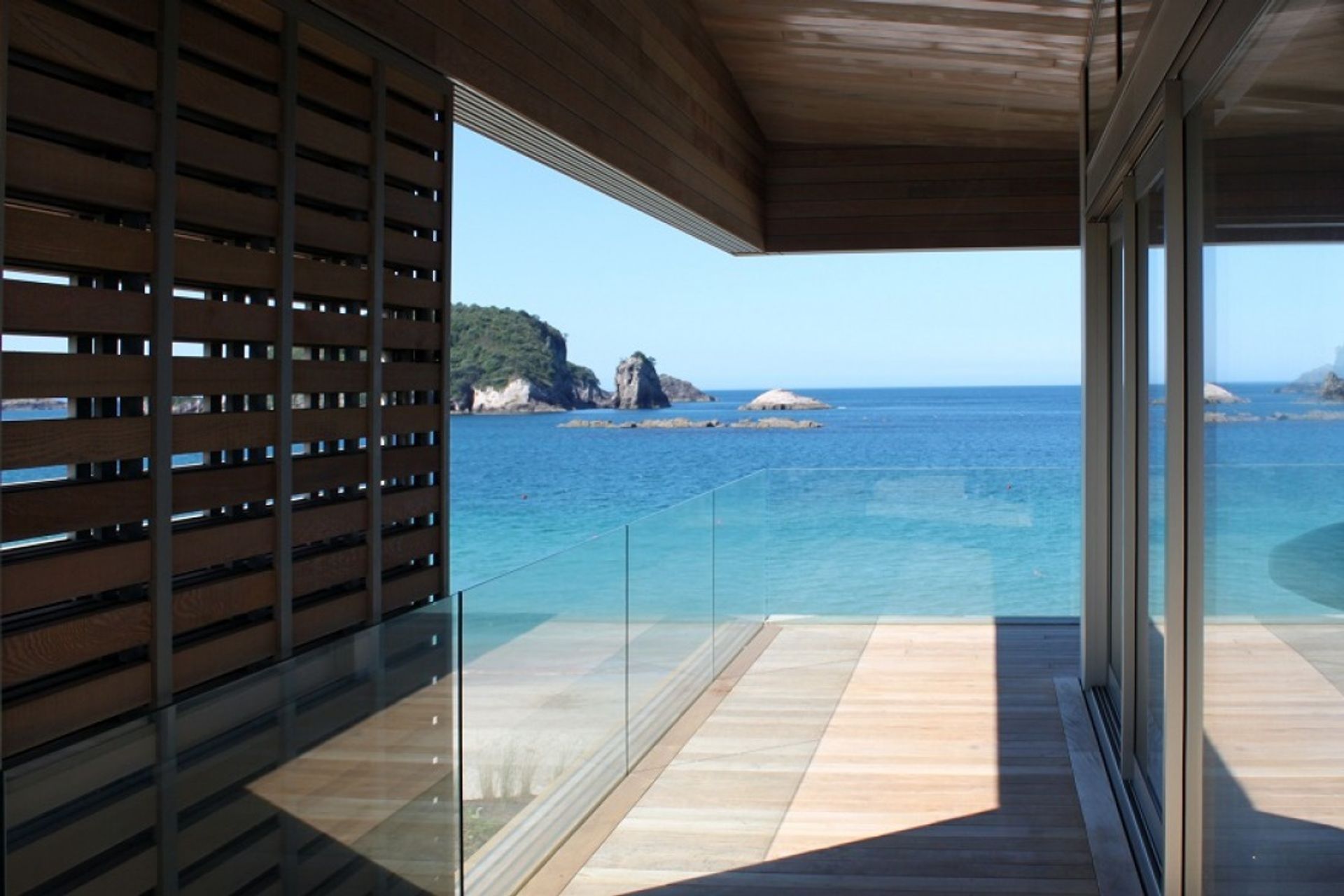 Large timber sliding screens, stair balusters, stair treads and front door of Hahei House by Studio2 Architects were all custom made by Grandvue Joinery.