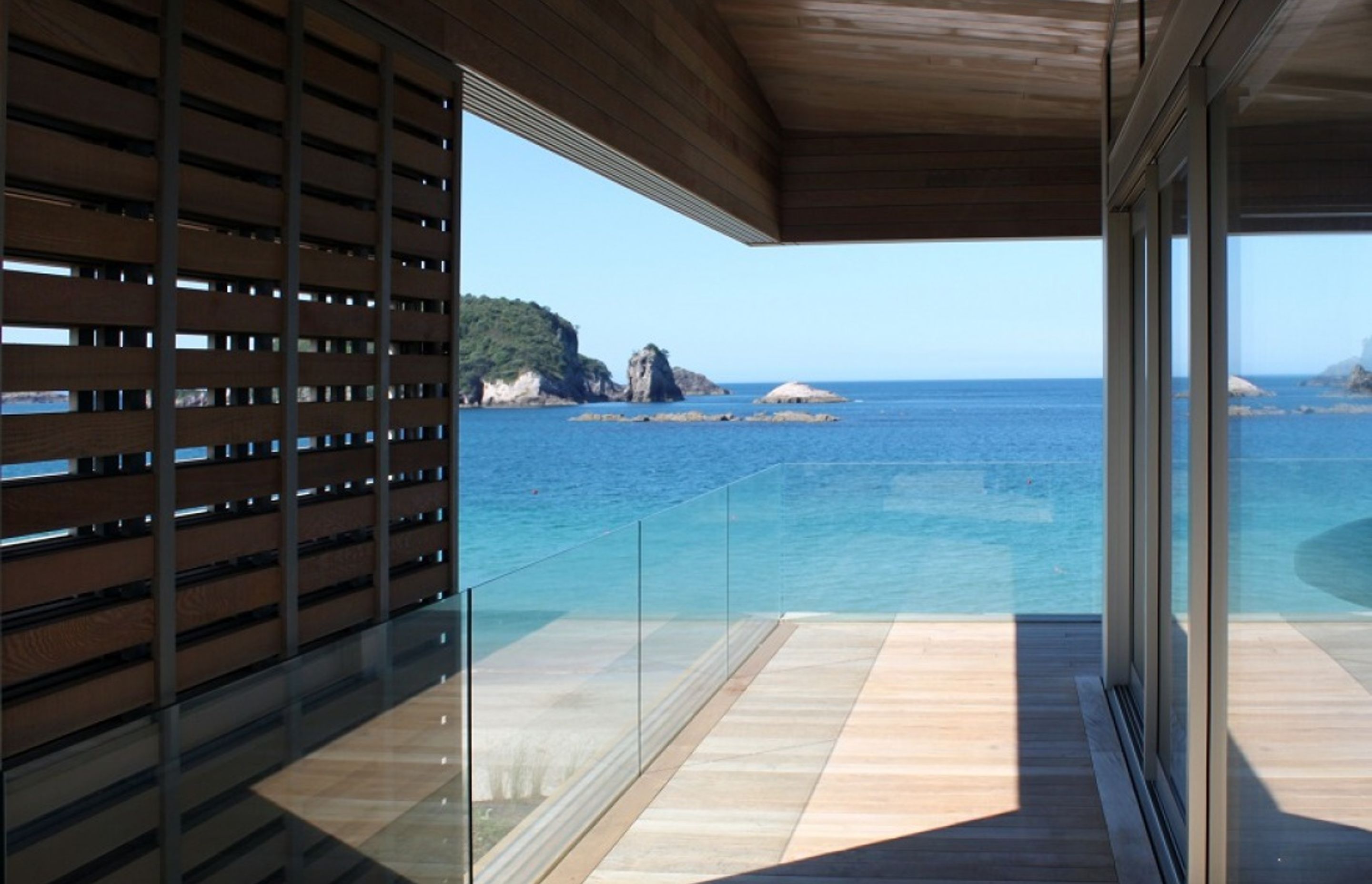 Large timber sliding screens, stair balusters, stair treads and front door of Hahei House by Studio2 Architects were all custom made by Grandvue Joinery.