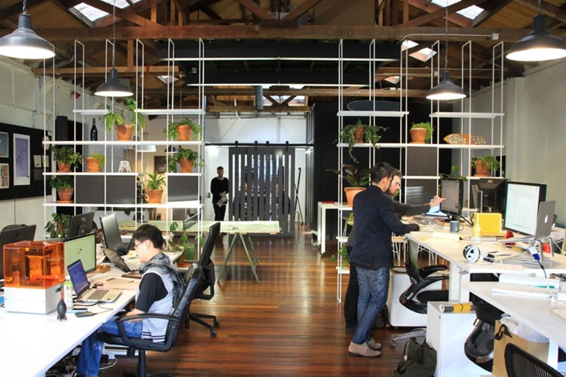 The open plan office for Think and Shift design studio uses panels and squares of acoustic materials to manage sound.