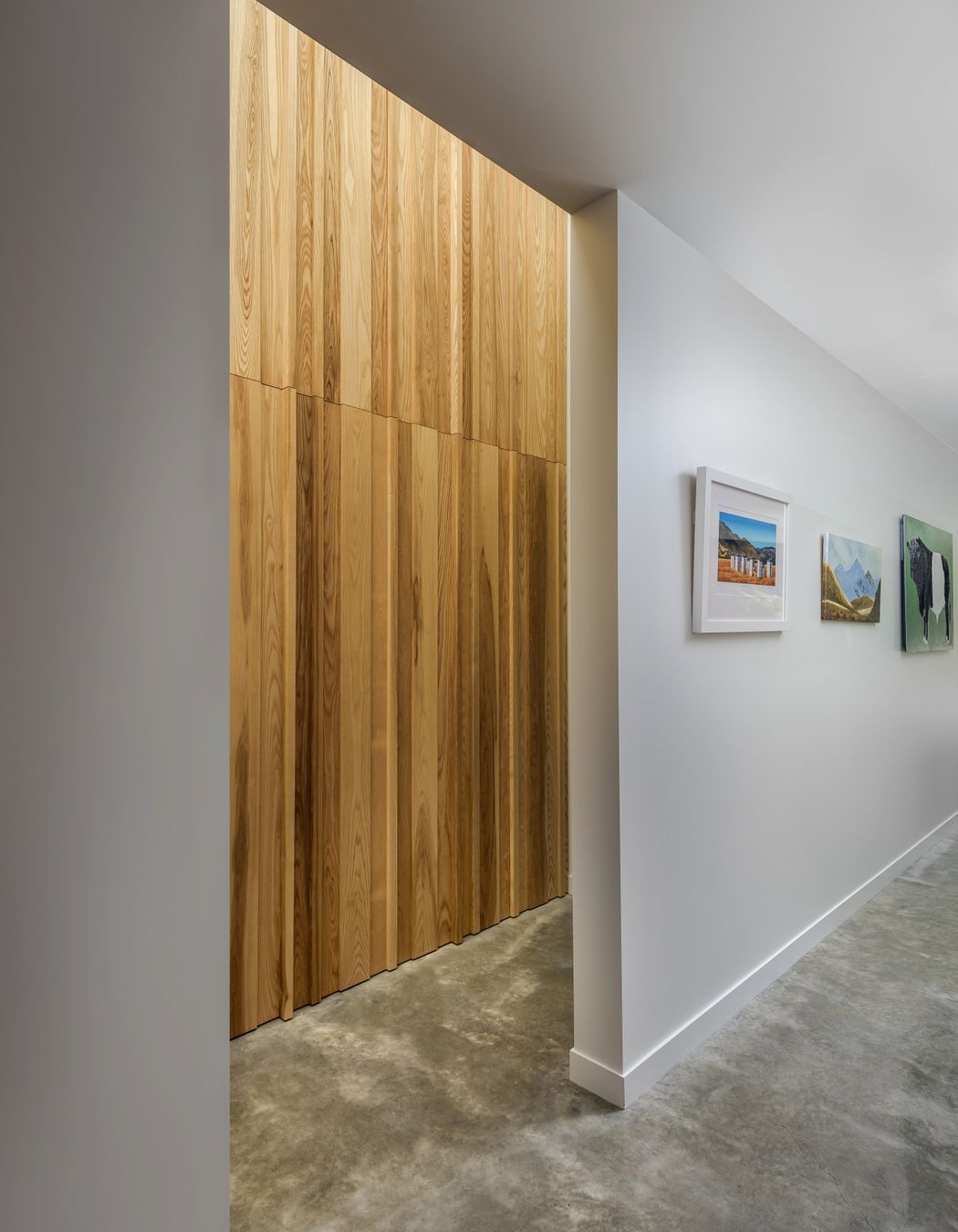 Randomly placed timber boards create a textural feature wall that conceals the entry to the bathroom off the hallway.