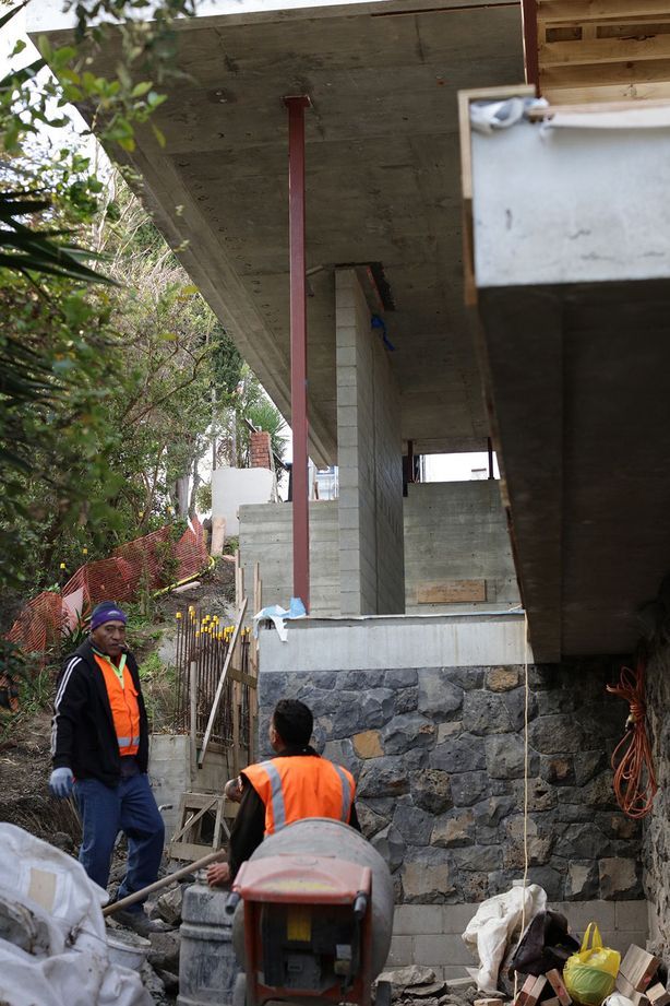 Work being done on the stone wall underneath the second-floor overhang.