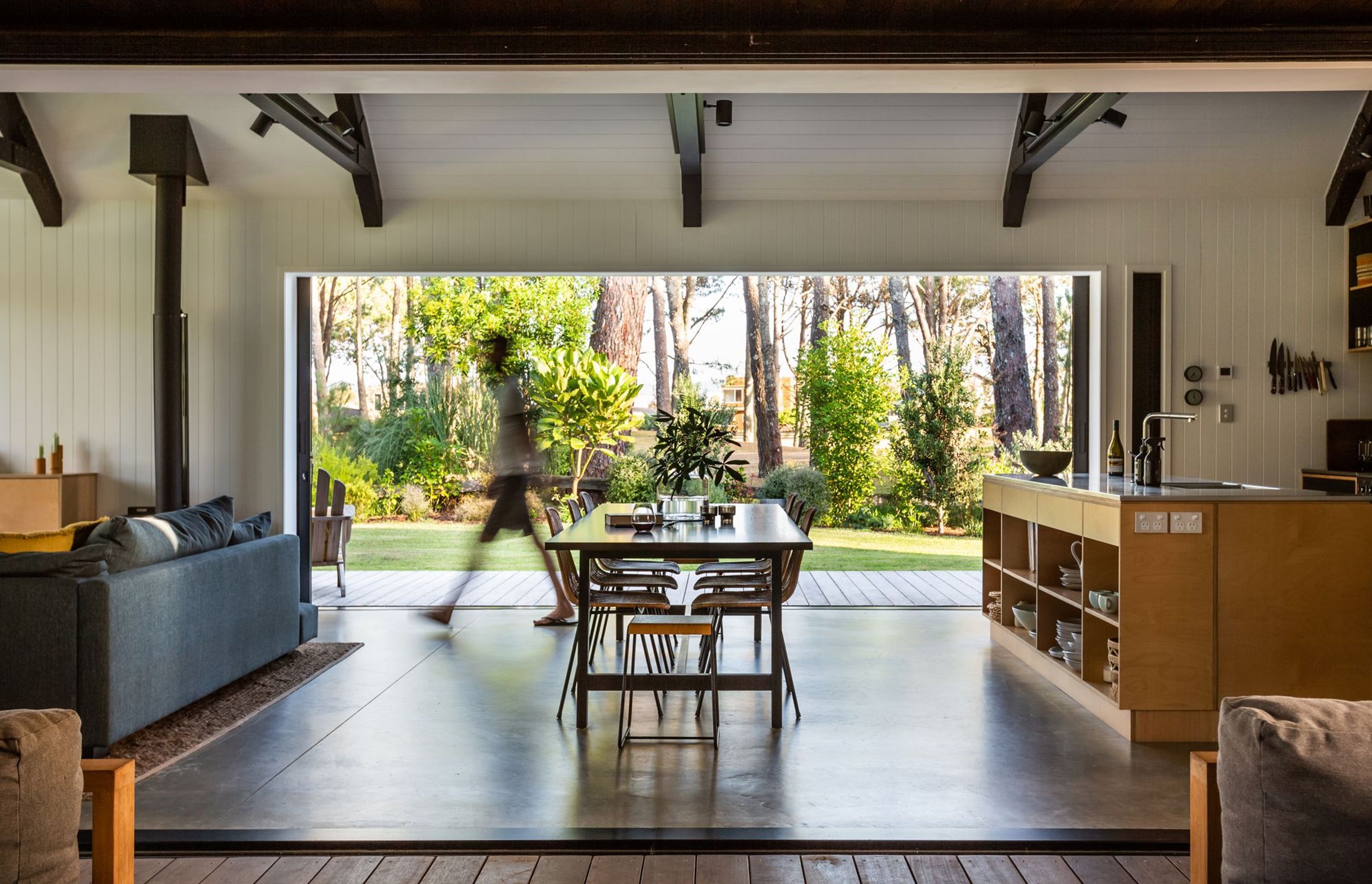 The main living area and kitchen are framed by the trees that define the site and its boundaries.