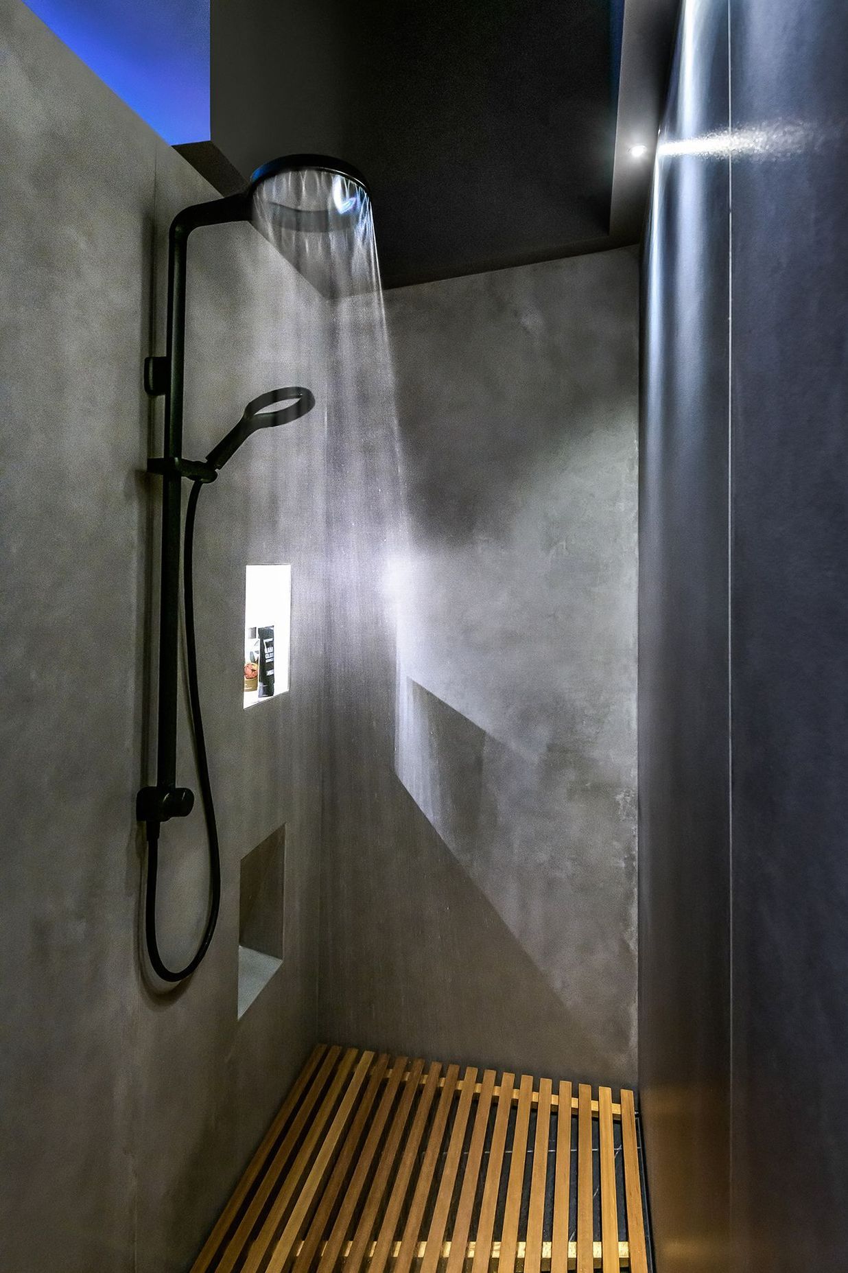 The minimalist shower has a Japanese feel with.a slatted timber floor.