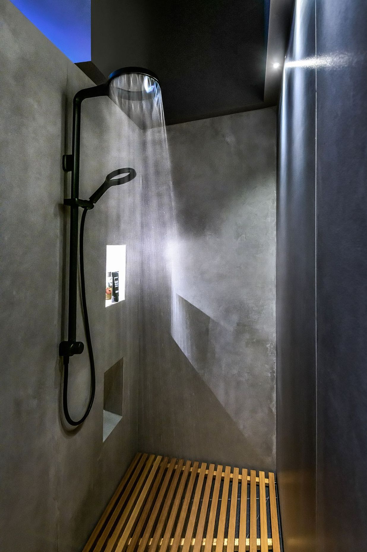 The minimalist shower has a Japanese feel with.a slatted timber floor.