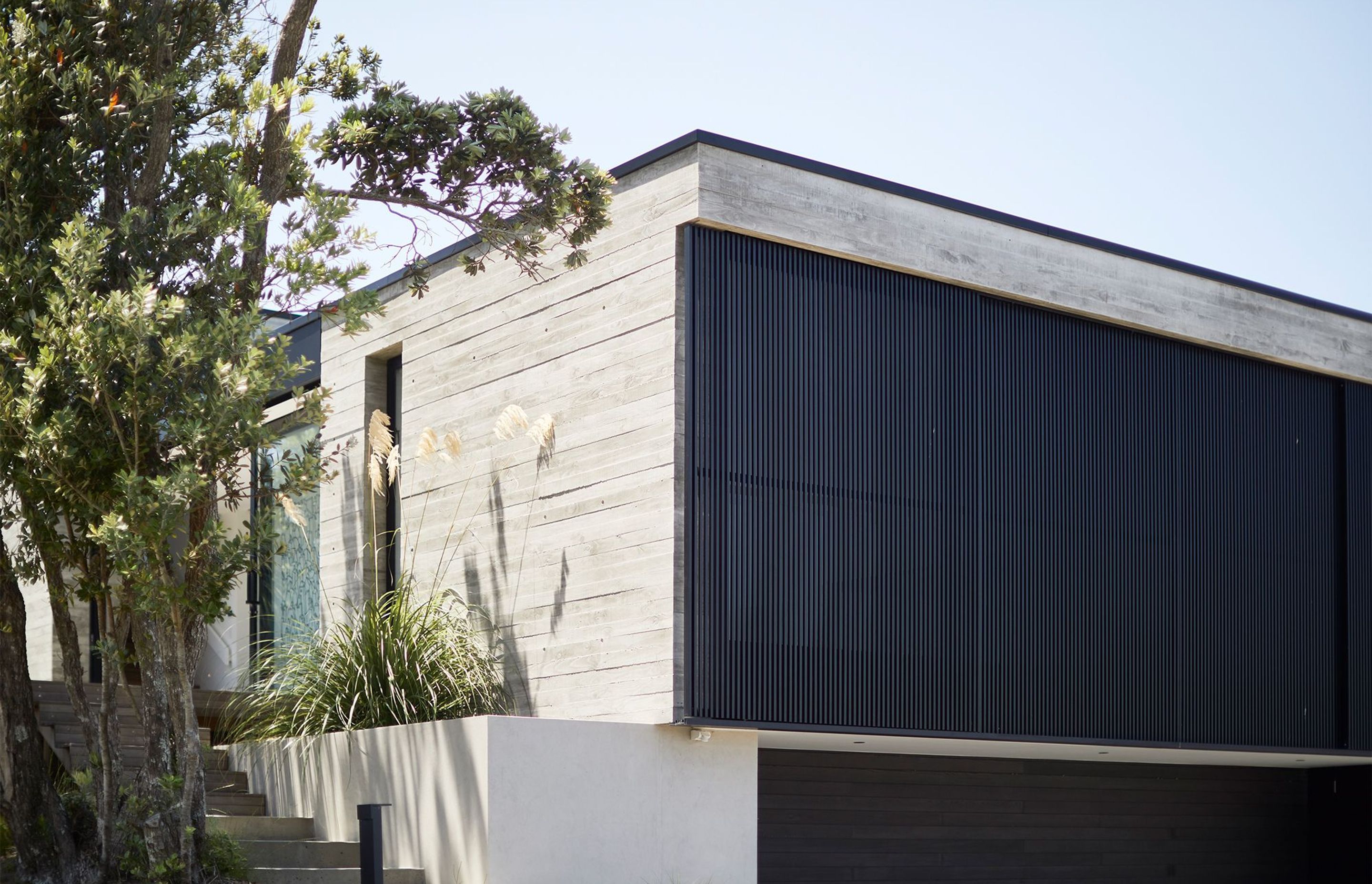 The garaging is flanked by two planter boxes that provide structural support for the higher storeys; they are the only two elements of the exterior that are not in situ concrete.