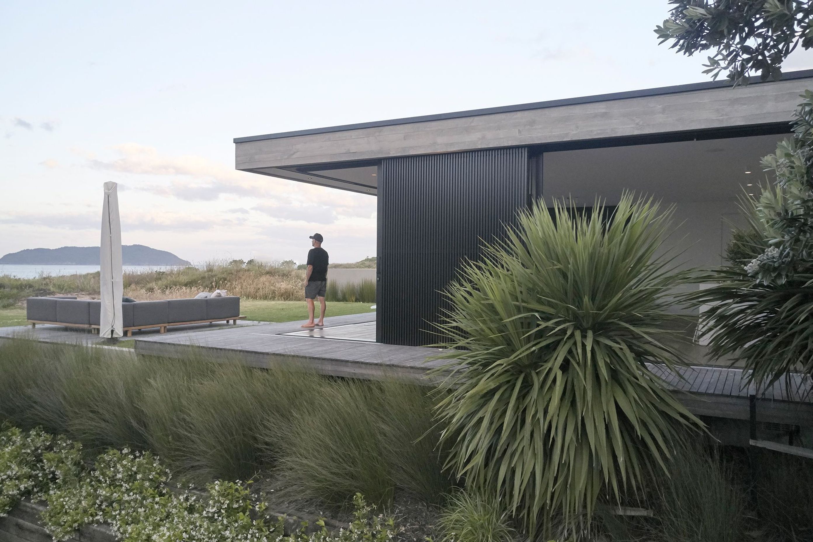 Adjacent to the dining area, a floating deck disconnected from the house sits in the grass, close enough to the dunes that the feeling of being within them is inescapable.