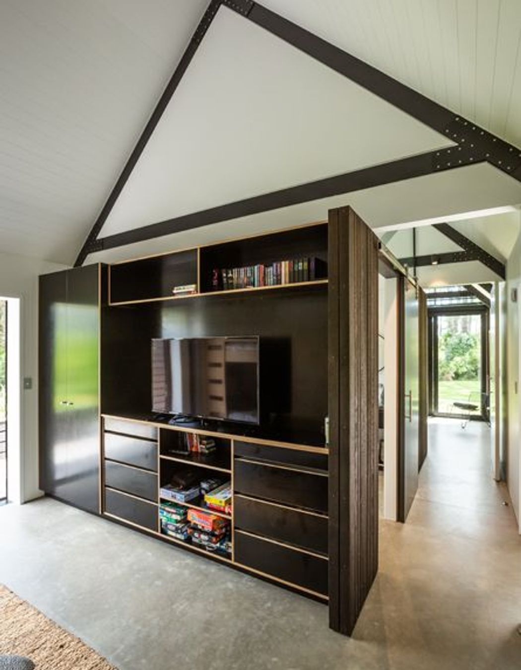 The exposed concrete floor creates a raw, relaxed aesthetic. 