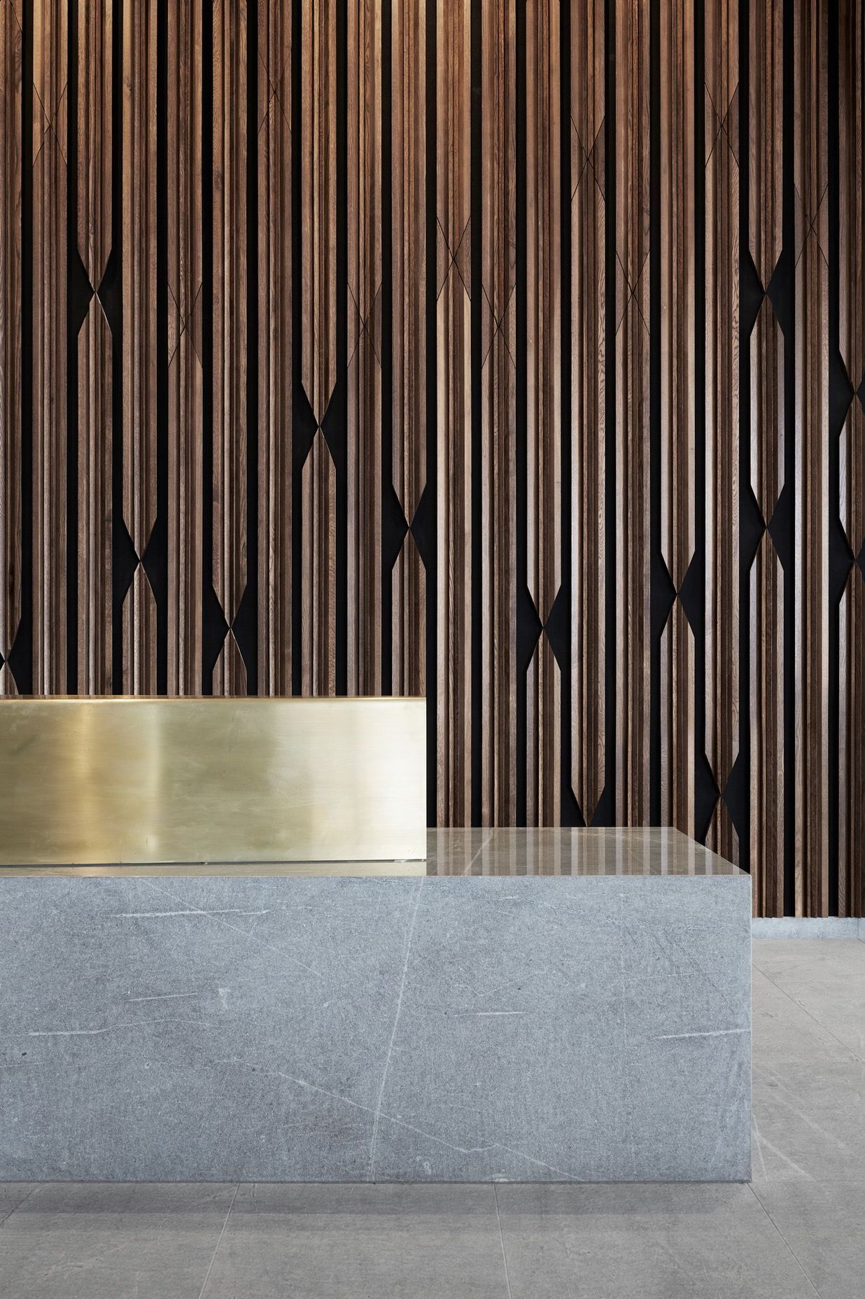 Materials on the ground floor are distilled to stone, timber and brass.