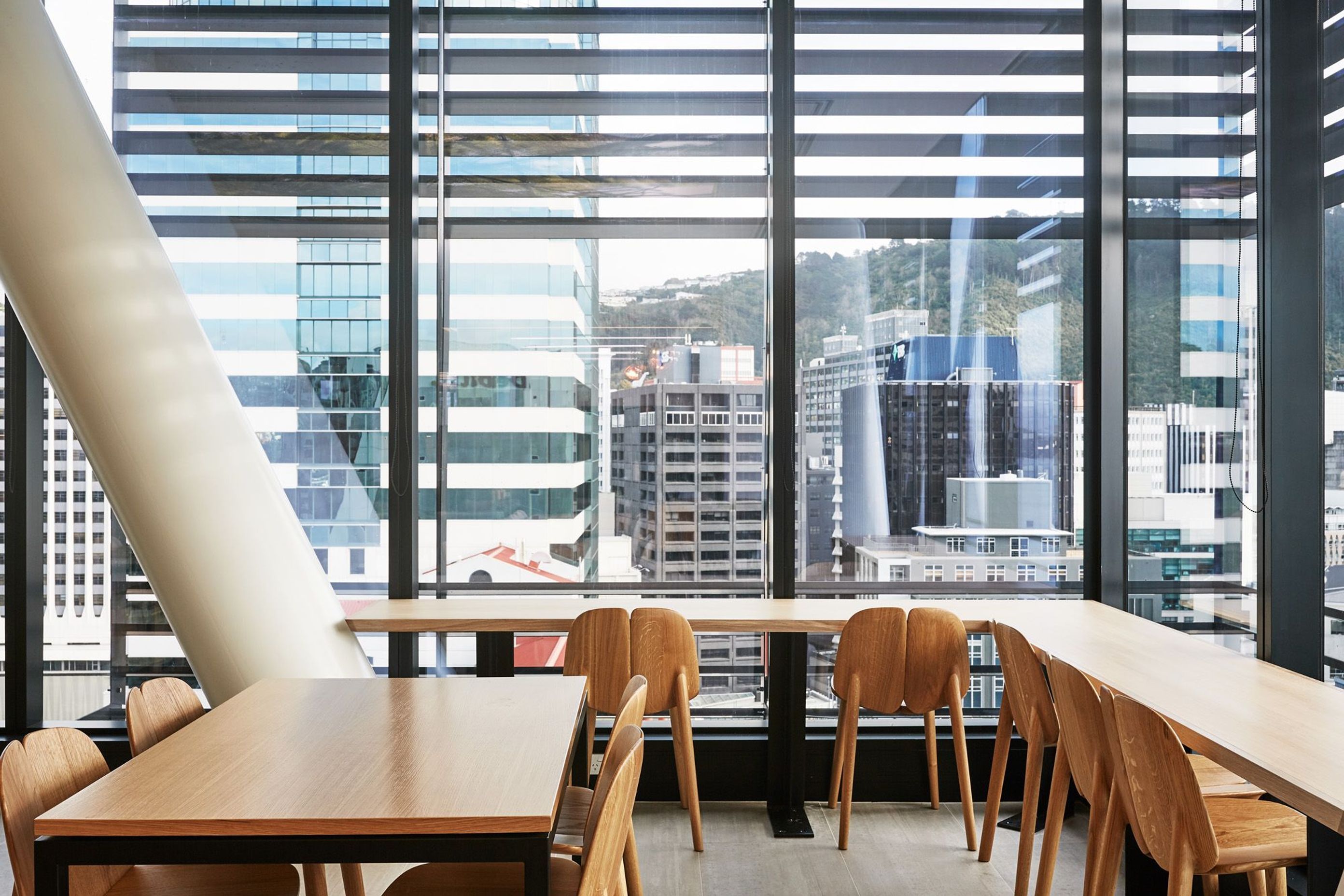 Wooden tables and seating provide a nice contrast to the steel structure and glazing, creating a warm and inviting atmosphere for staff.