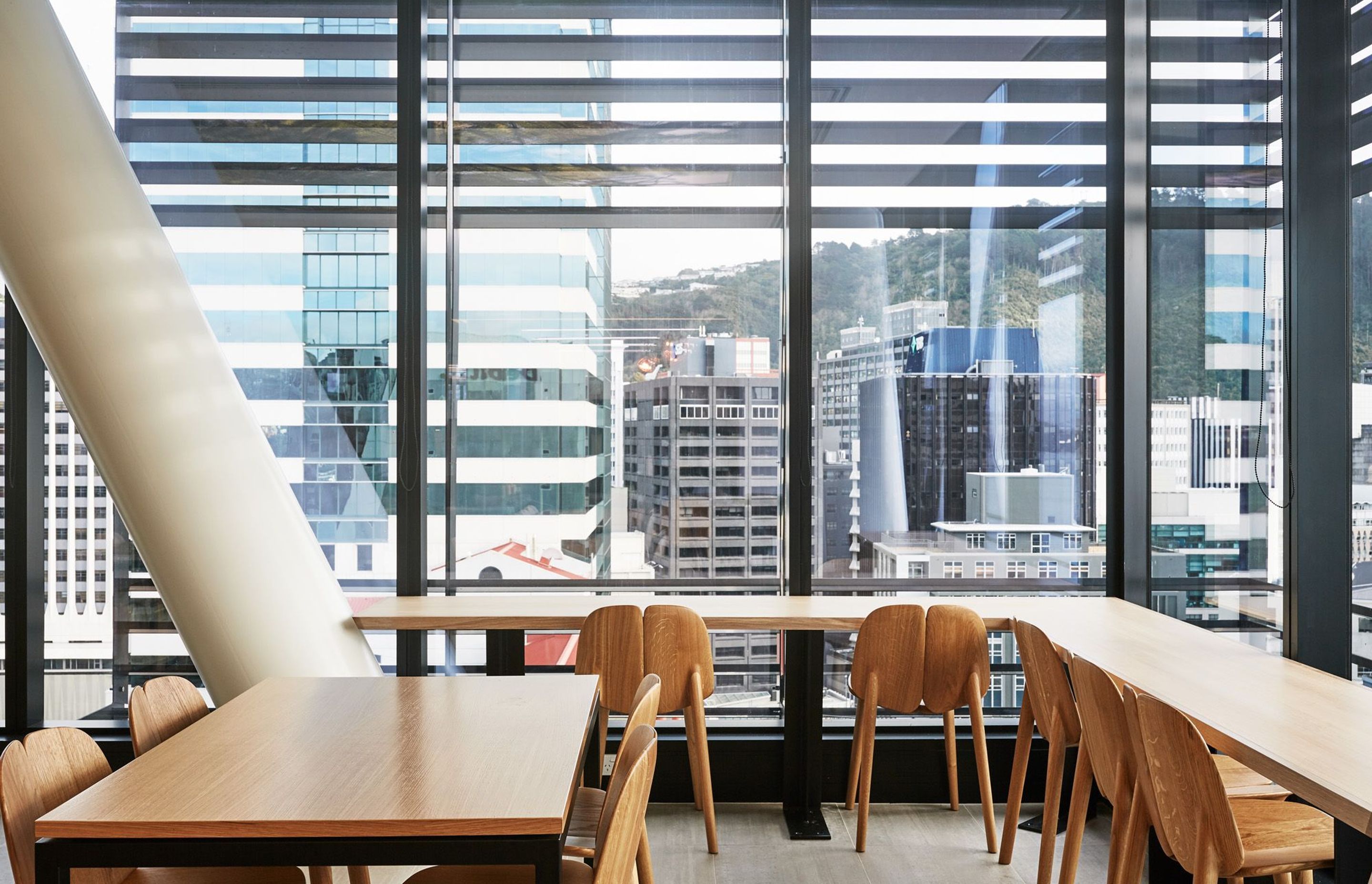 Wooden tables and seating provide a nice contrast to the steel structure and glazing, creating a warm and inviting atmosphere for staff.