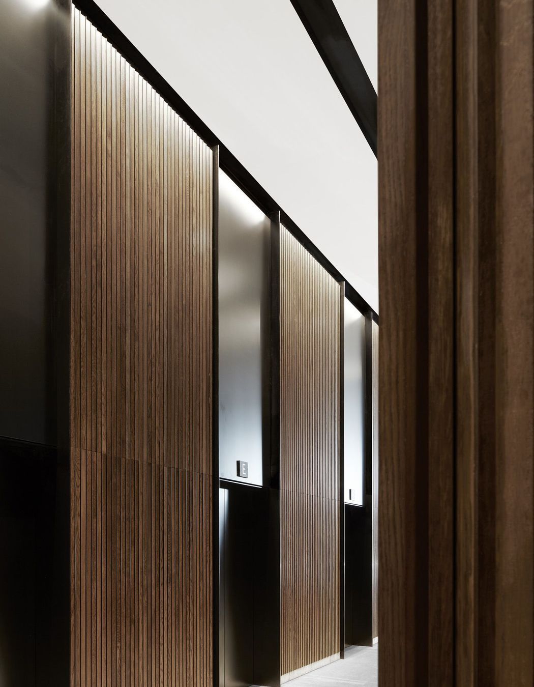 The circulation core is clad in timber panelling with black aluminium lifts.