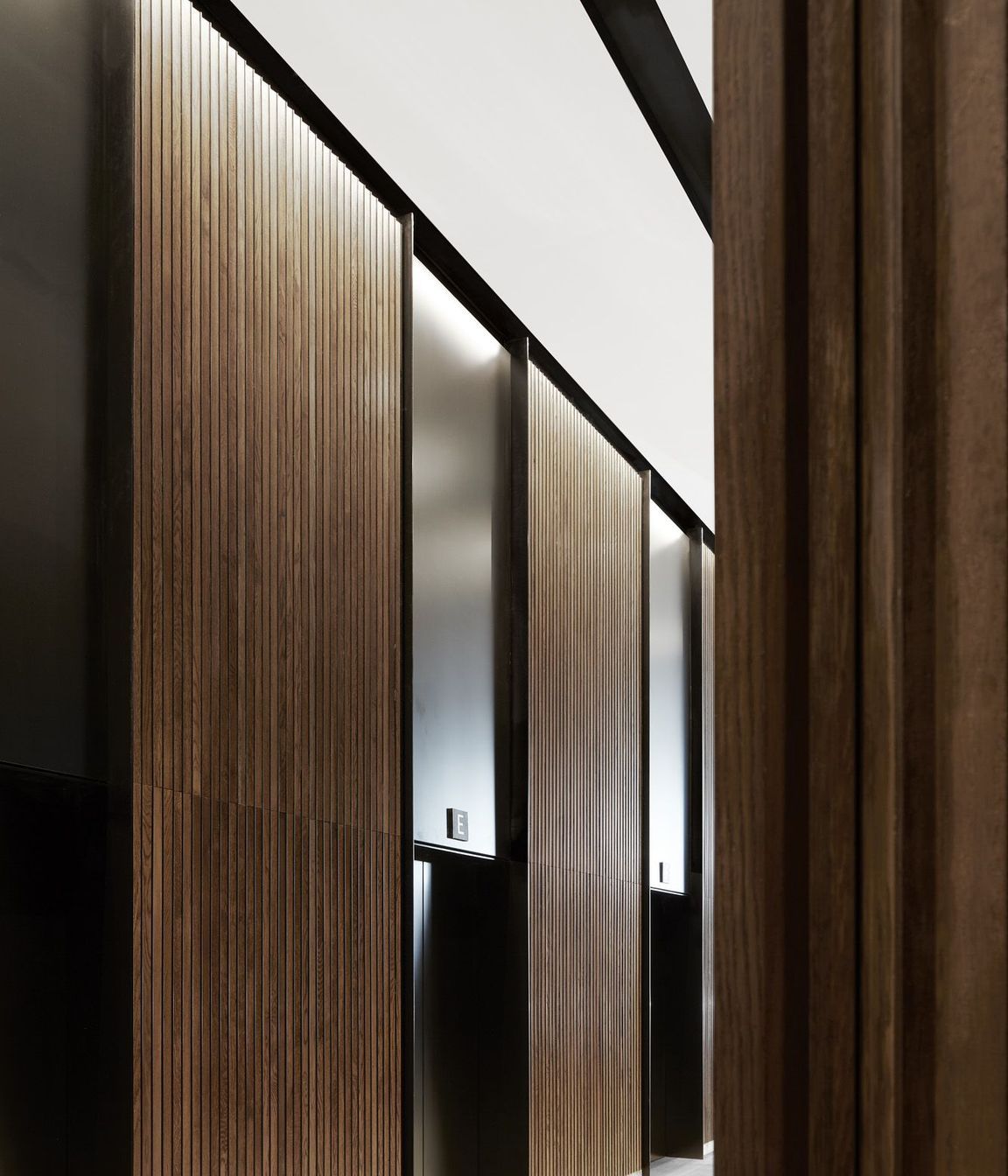 The circulation core is clad in timber panelling with black aluminium lifts.