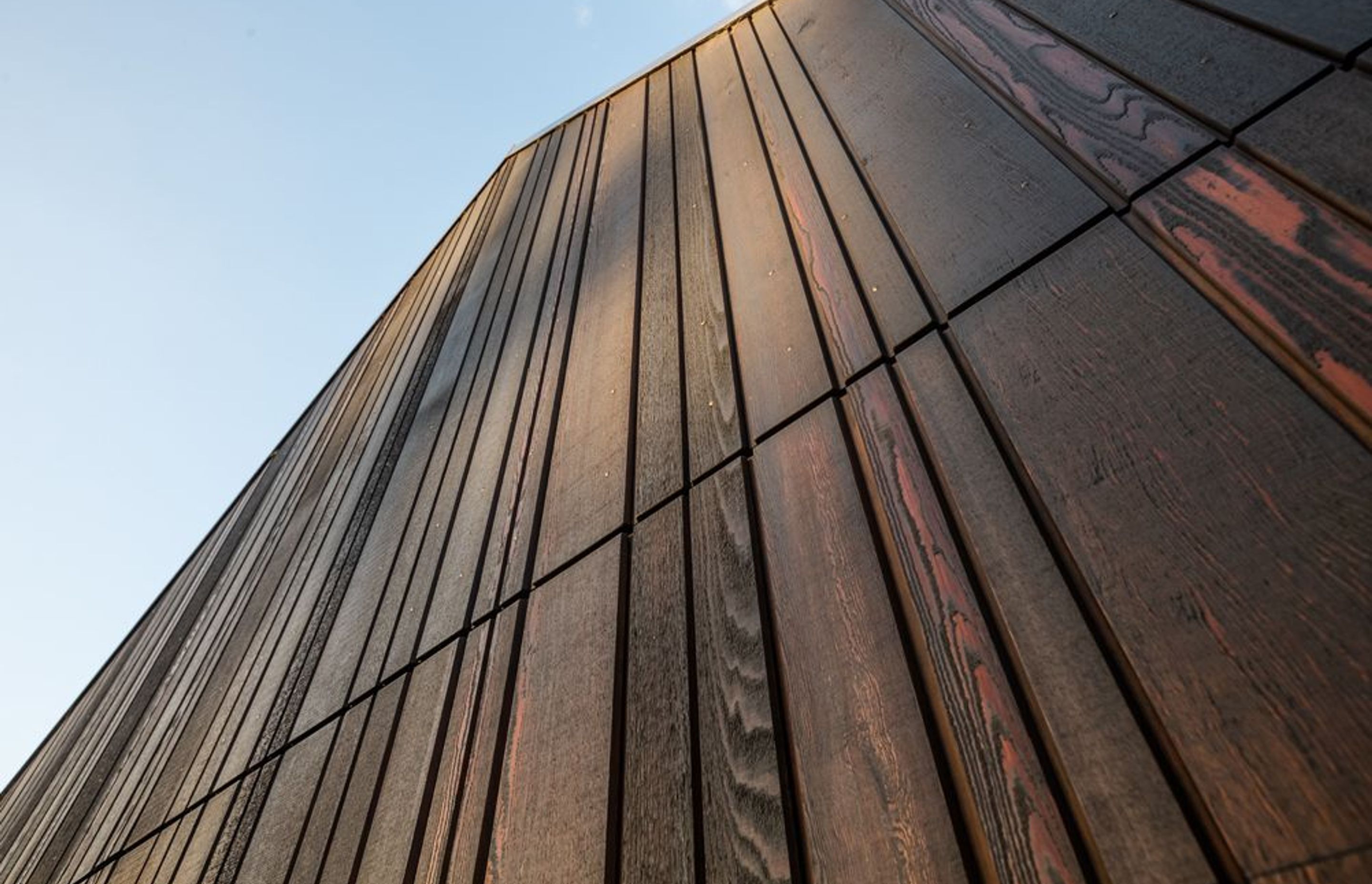 The cabins have clarity in form and structure, clipped geometry, and dark cedar cladding and roofing, enabling them to sit quietly but firmly against their green surroundings.