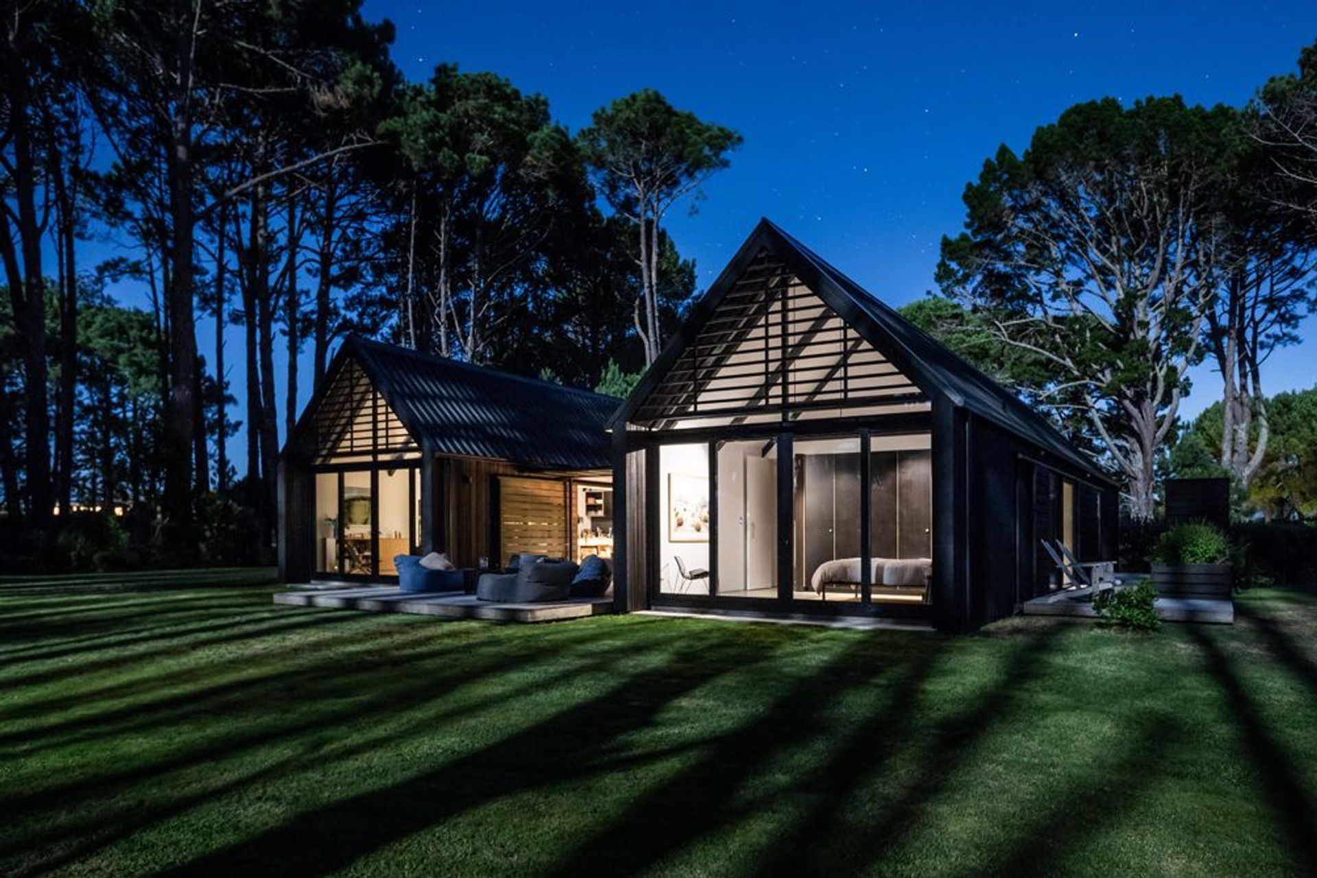 On the other facade, a sense of openness prevails. Here, the home opens out to the main deck and a belt of pine trees that flank the sand dunes.