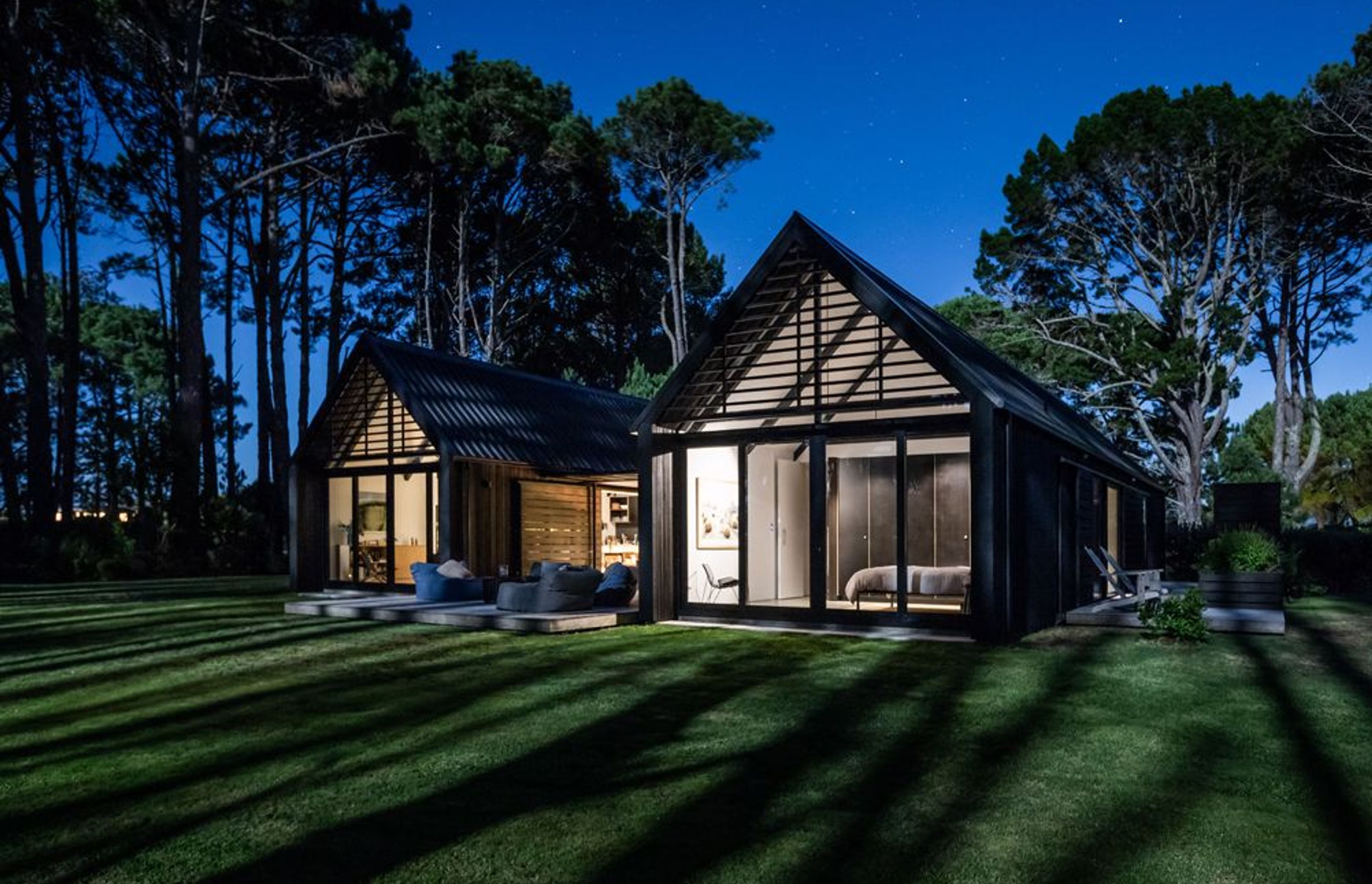 On the other facade, a sense of openness prevails. Here, the home opens out to the main deck and a belt of pine trees that flank the sand dunes.