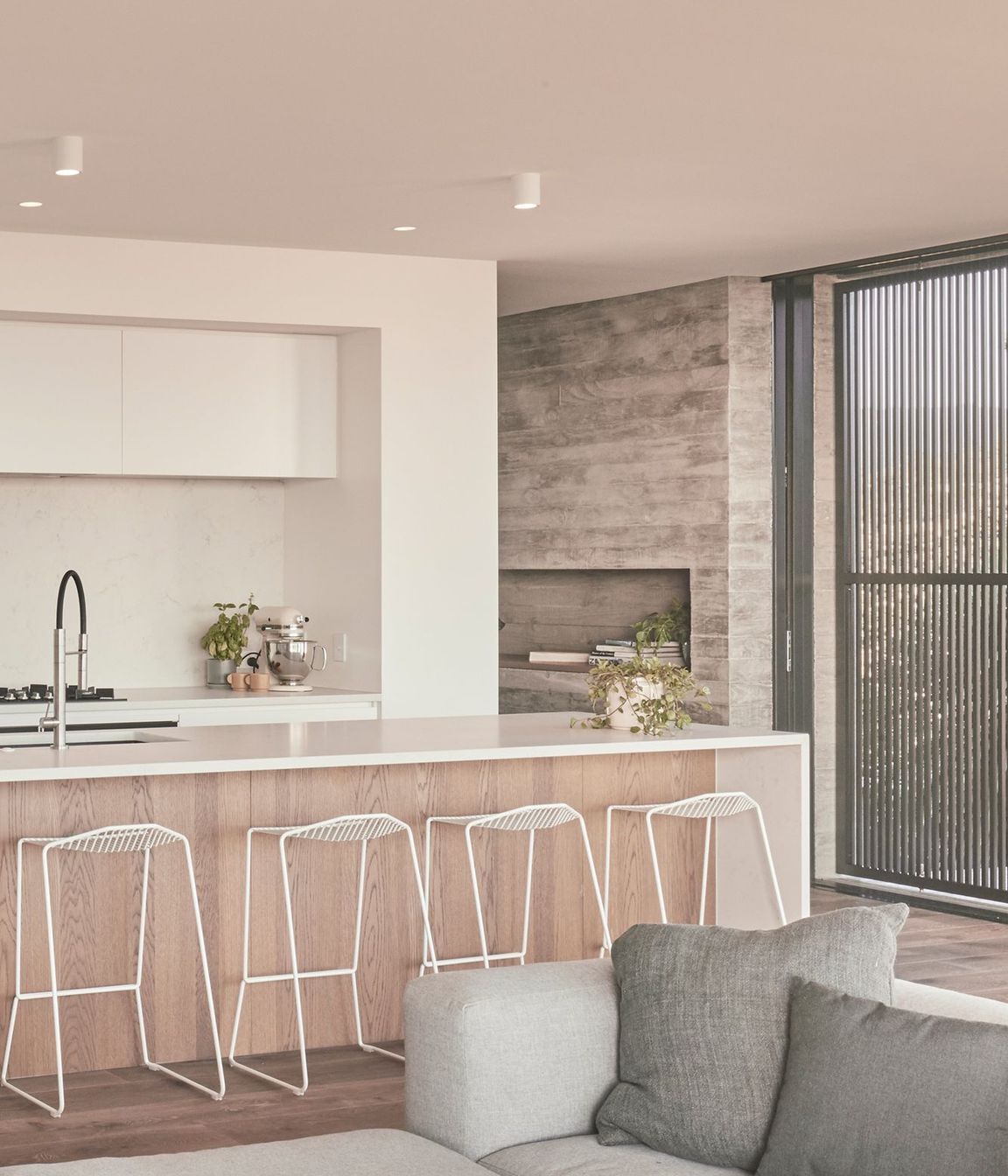 The kitchen is the only area in the house where there is a deviation from a textural, natural palette of materials. Here, it is stripped back to stark white and an oak floor.  